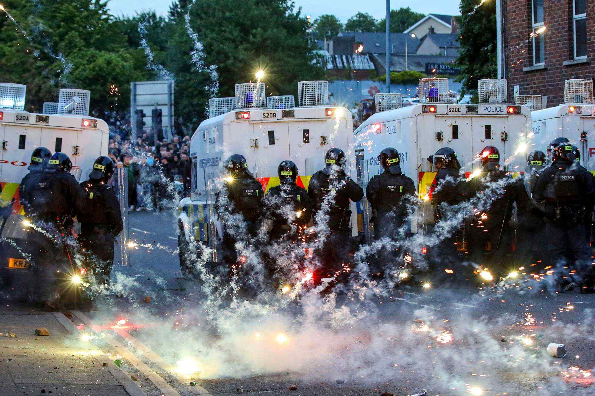 Fireworks thrown at riot police illuminate the road during a protest in Ballymena on June 11. Photo: AFP