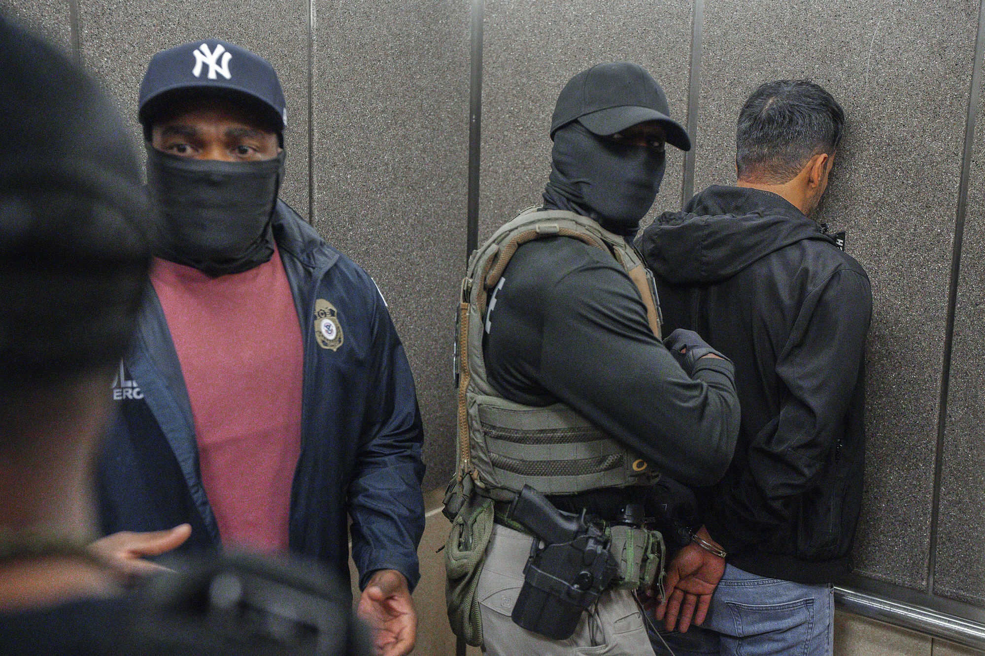 Masked ICE officers detain a migrant after he exited an immigration courtroom. The Trump administration has ordered officials to increase detentions to 3,000 migrants per day. Photo: AP
