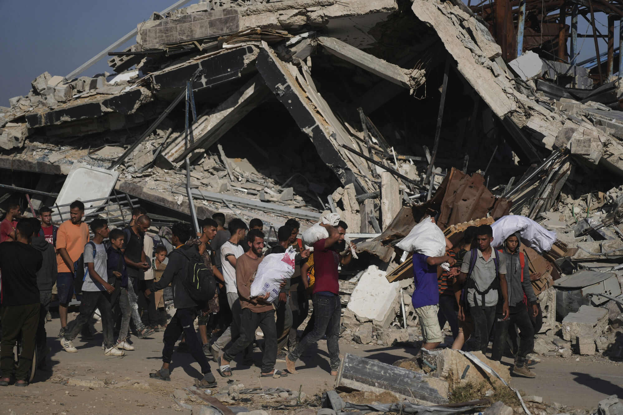 Palestinians carry aid distributed by an Israeli and US-backed organisation in Khan Younis, southern Gaza Strip. Photo: AP