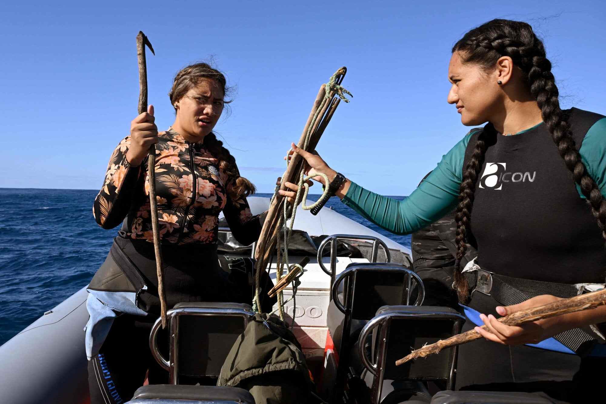 Sisters Konini Rongo (L) and Myria Rongo prepare to dive with makeshift tools to collect crown-of-thorns starfish. Photo: AFP