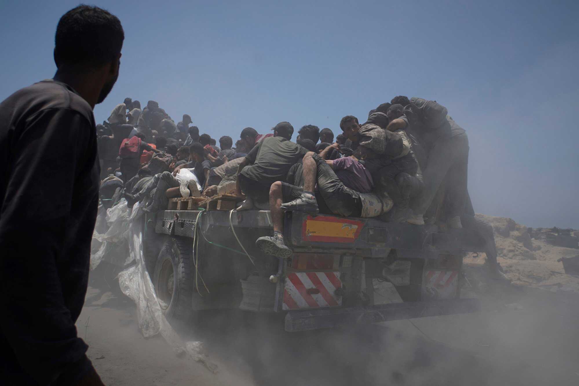 Palestinians hold onto an aid truck returning to Gaza City from the northern Gaza Strip on Tuesday. Photo: AP