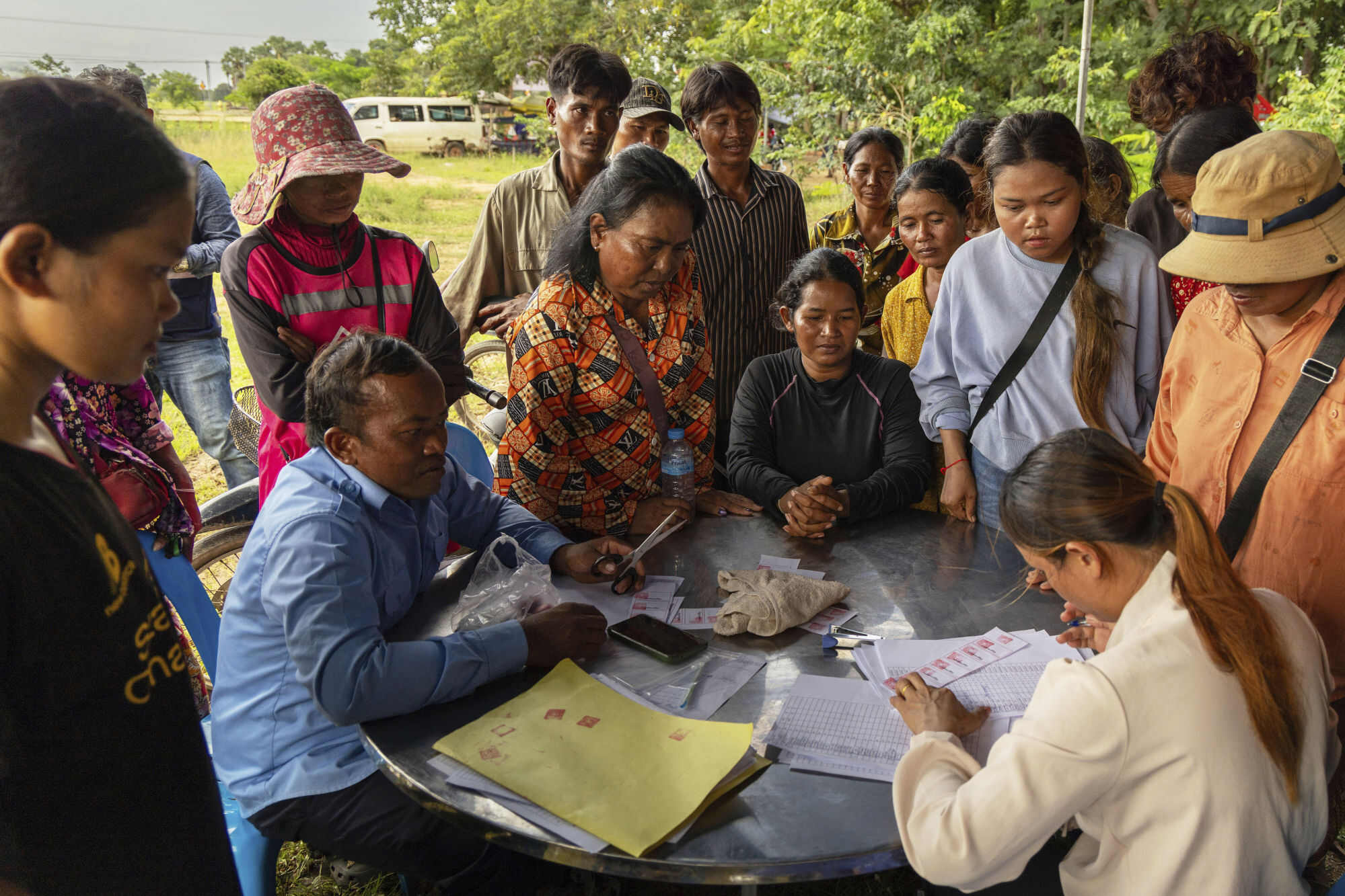 A Srei Snam district official (right) works to register dozens of displaced villagers in a newly established resettlement site in Wat Velevorn in Siem Reap Province, Cambodia, on Monday, July 28. Photo: AP