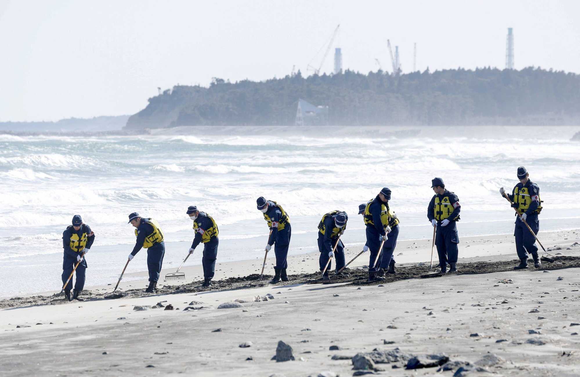 Police officers search for information about missing persons after the 2011 earthquake and tsunami disaster in Namie-town, Fukushima prefecture, Japan. Photo: Kyodo via Reuters