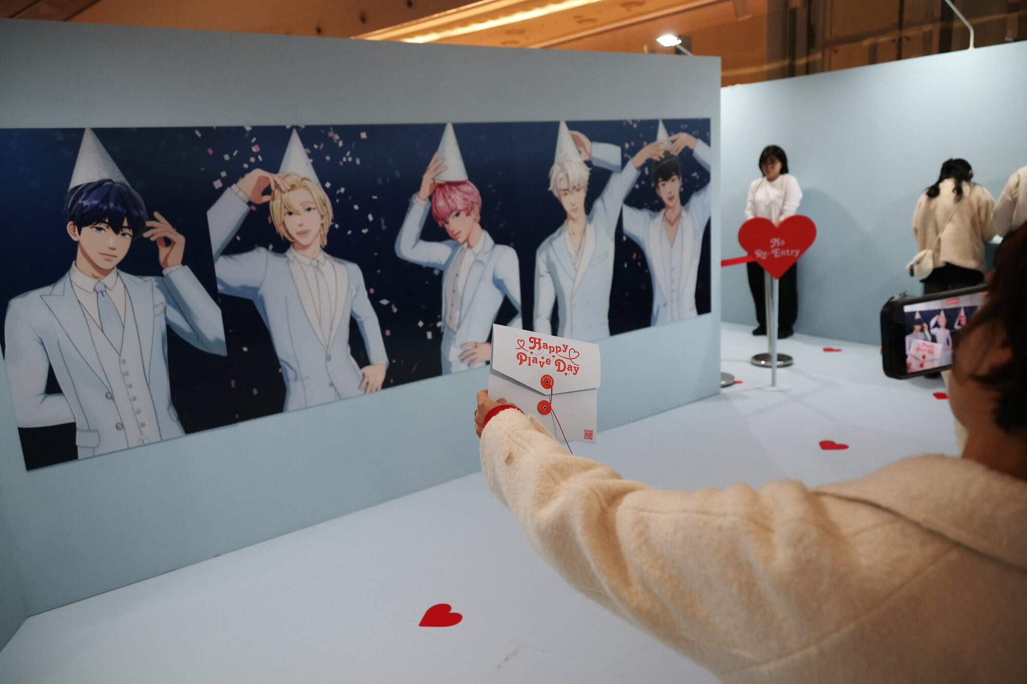 A fan takes a photo with portraits of members of the virtual K-pop boy band Plave at a pop-up store in Seoul, South Korea. Photo: Reuters