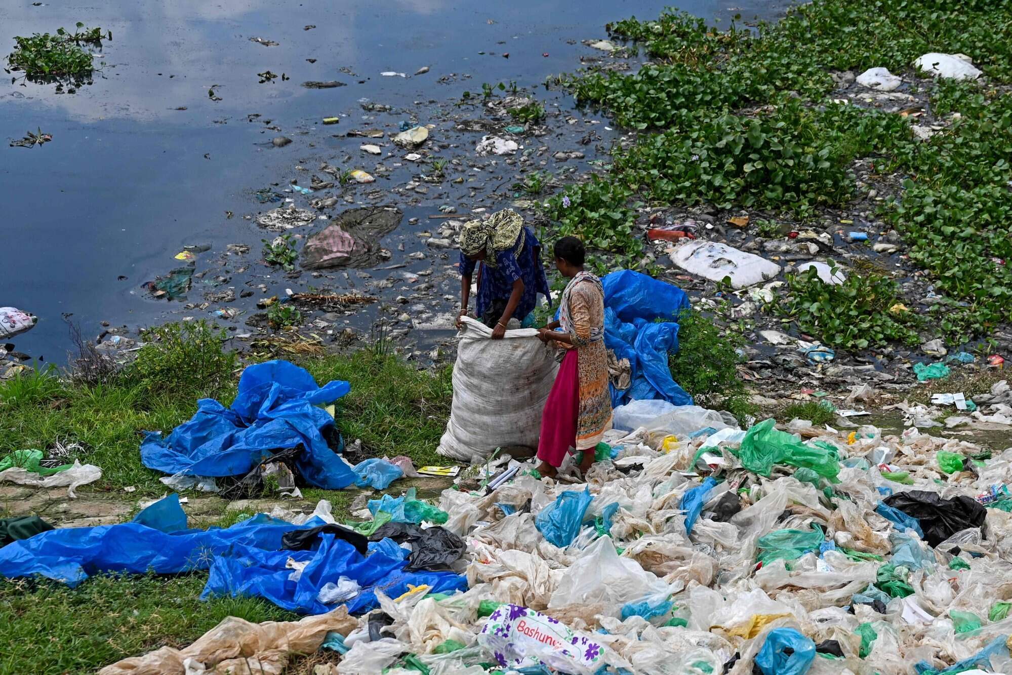 Ragpickers sort plastic bags for recycling in Dhaka, Bangladesh. Photo: AFP