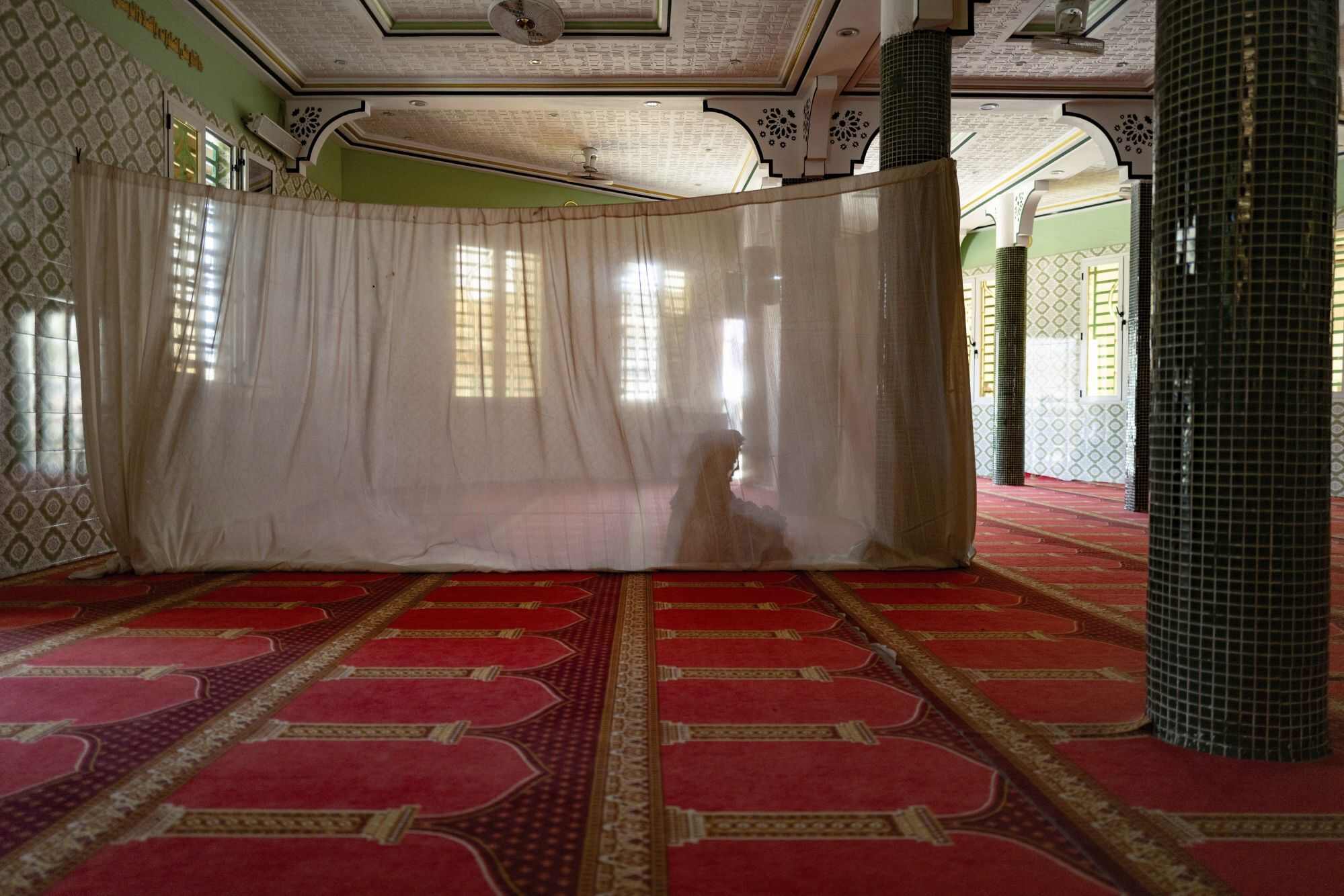 A woman prays in the designated section. Discussions for men also focused on girls’ rights, equality and the harmful effects of female genital mutilation. Photo: AP