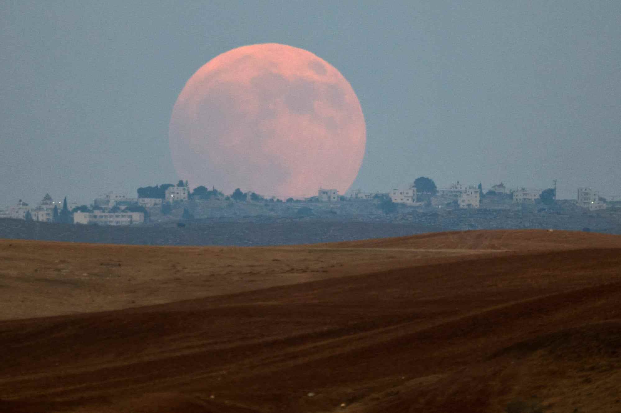The “blood moon” rises over the West Bank, as seen from the Negev desert in Israel. Photo: Reuters