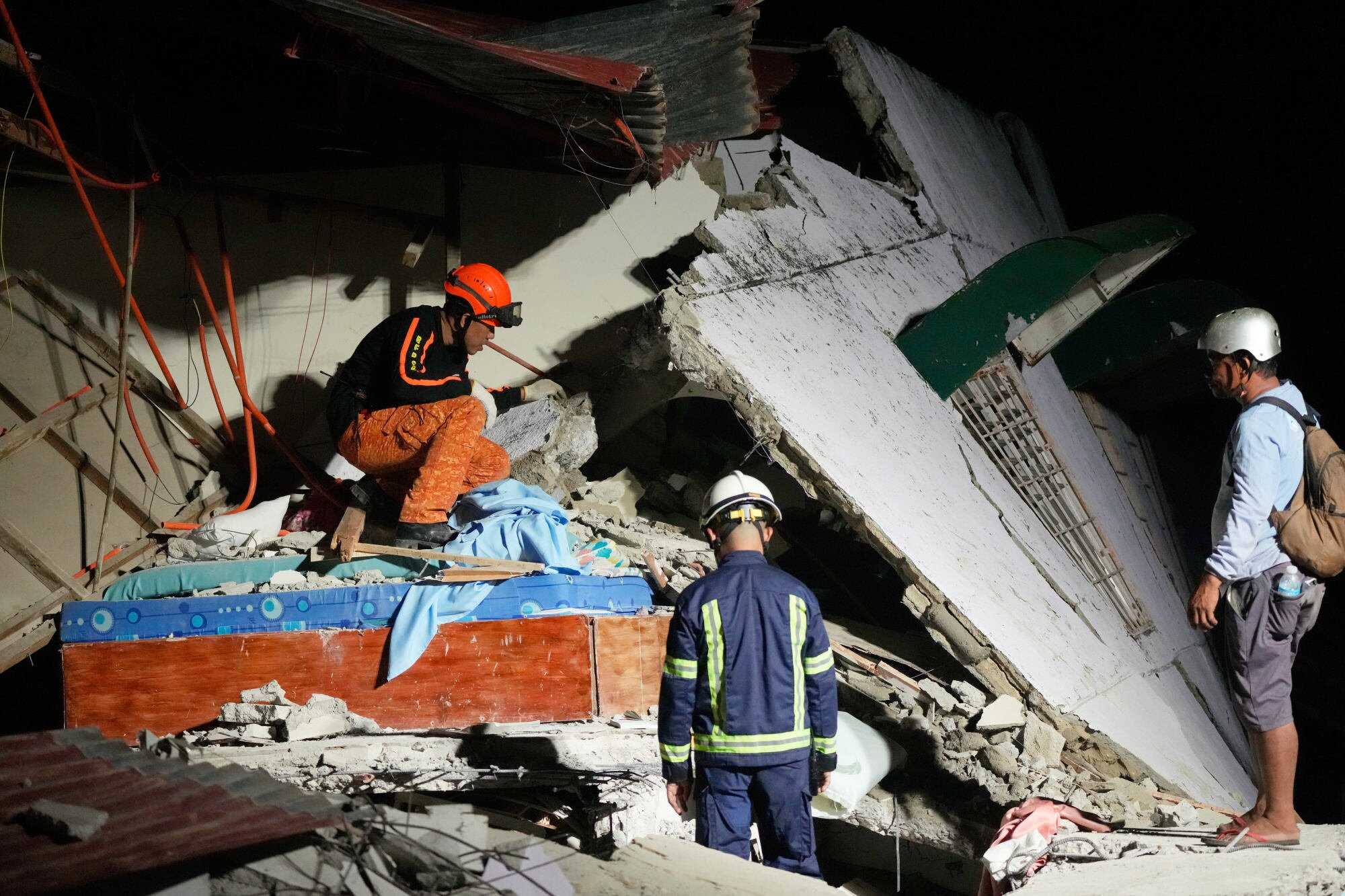 Rescuers look for survivors in the ruins of a collapsed building in Bogo city, Cebu, Philippines. Photo: AP