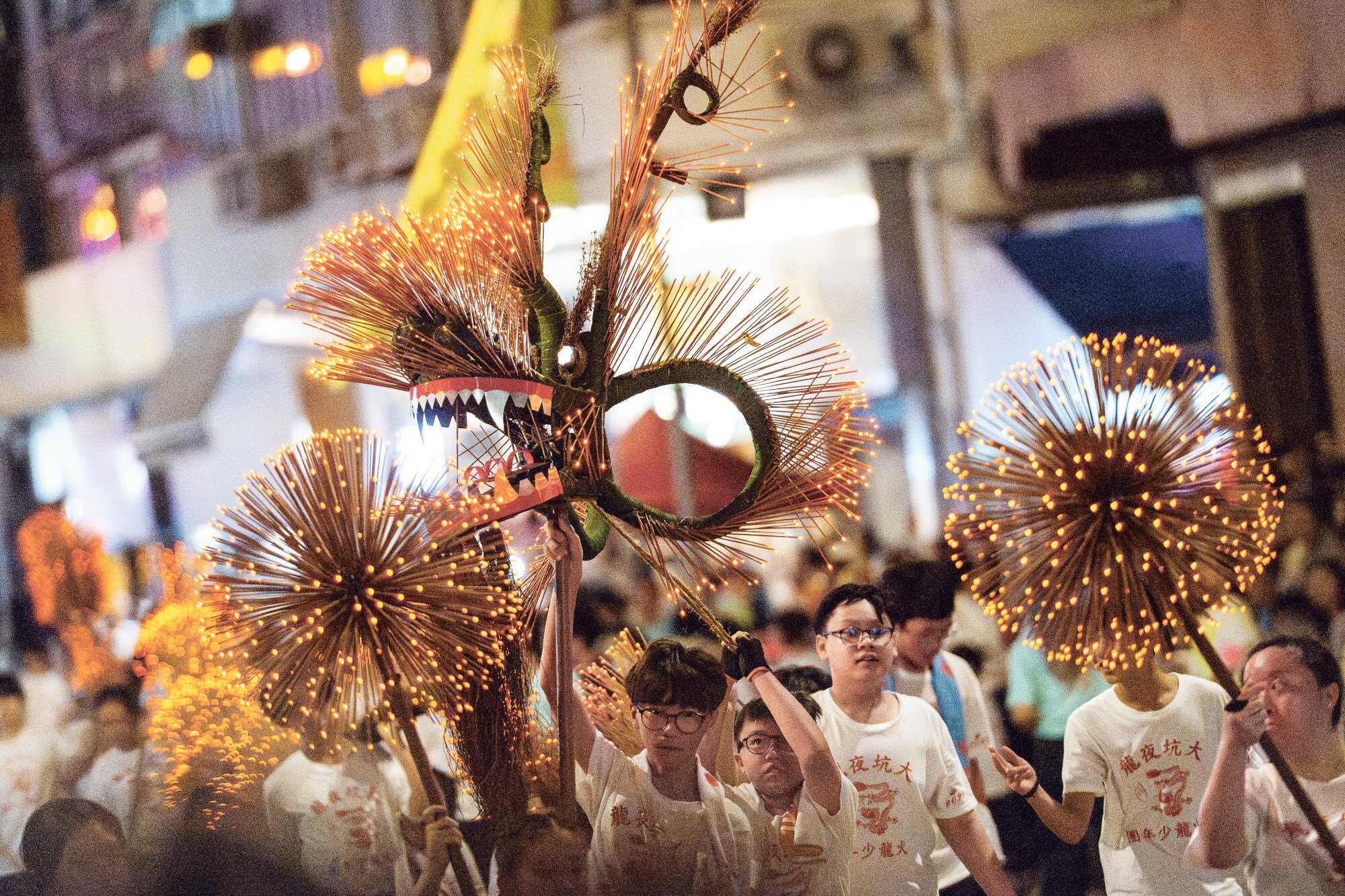 Children can participate in the event too, like those carrying a dragon made from LED lights instead of incense. Photo: Huy Truong