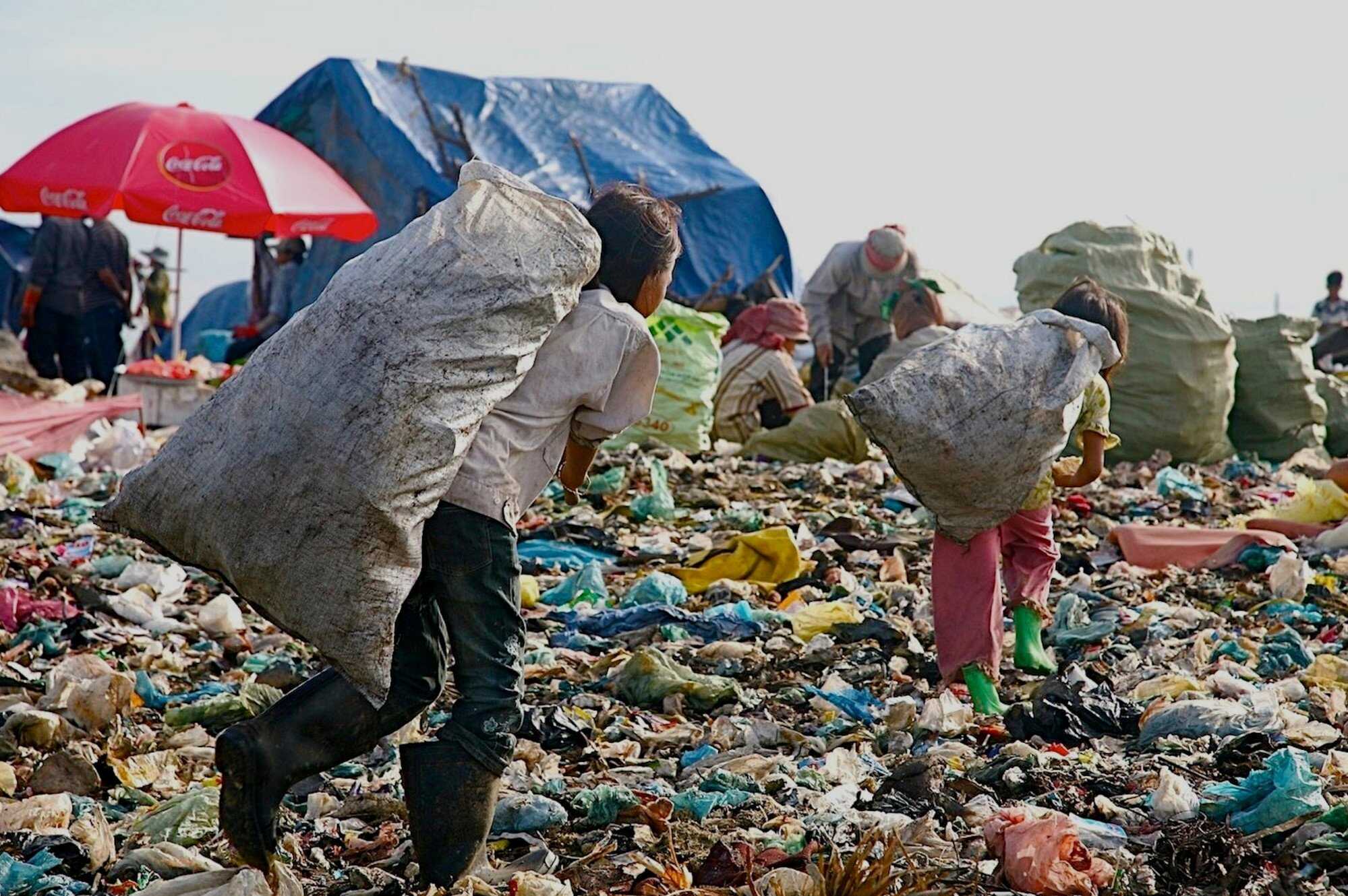 Srey Mom Ang (left) hauls a bag of rubbish at Stung Meanchey. Photo: Cambodian Children’s Fund