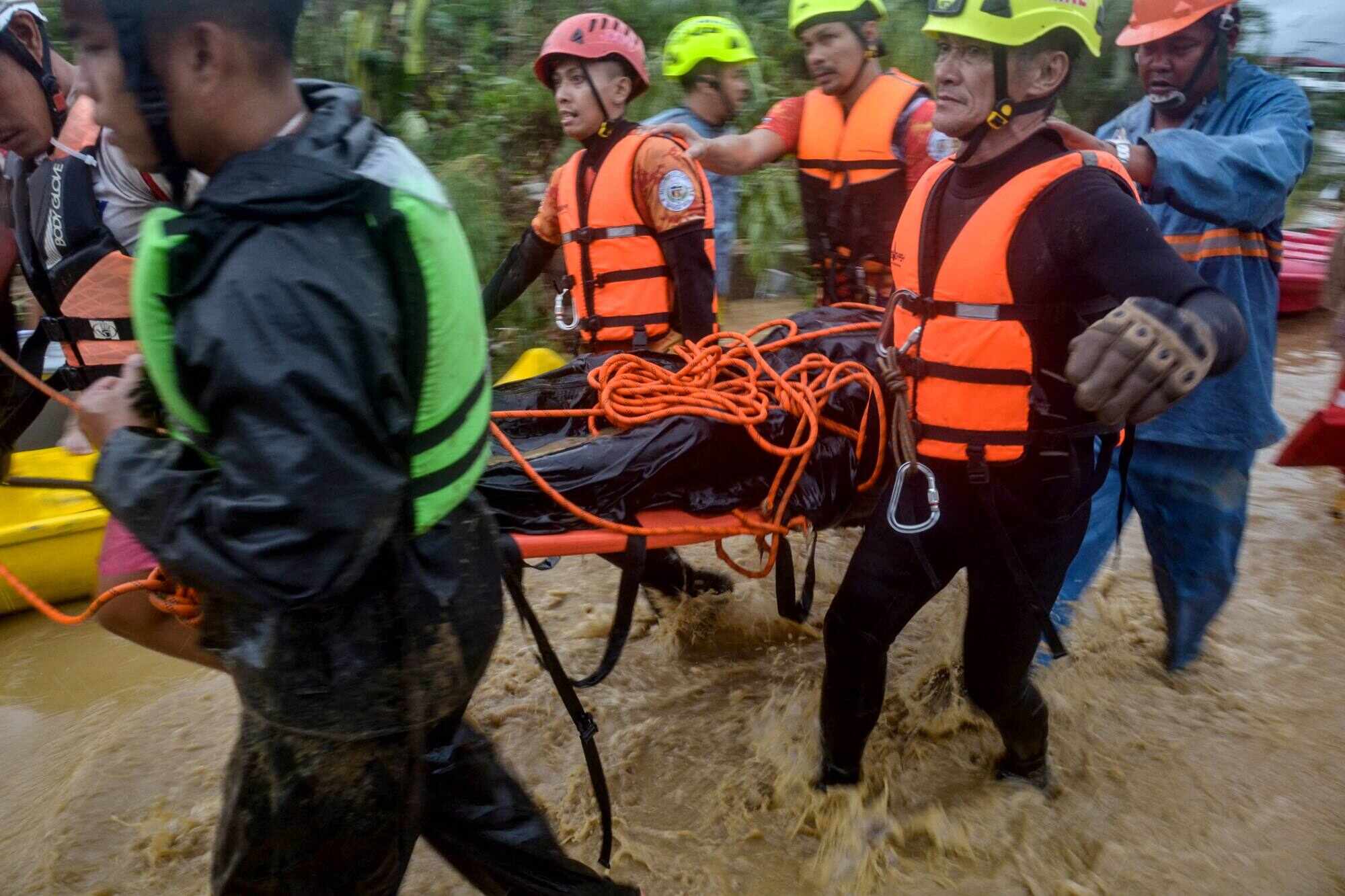 Rescuers evacuate a resident in Liloan town, Cebu province. Residents sought refuge on rooftops while cars floated through flooded streets. Photo: AFP