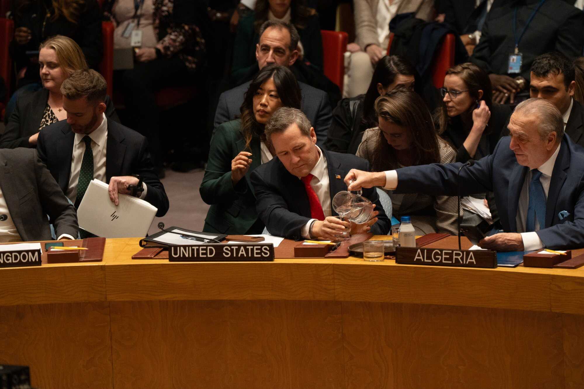Algerian UN representative Amar Bendjama (right) pours water for the US representative to the United Nations, Mike Waltz (centre). Photo: EPA
