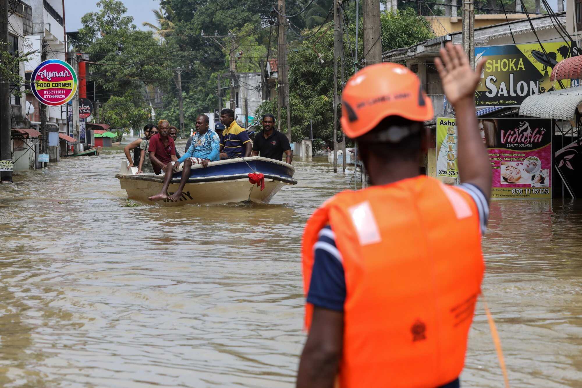 Rescue personnel evacuate residents by boat from a flood-affected area after heavy rainfall in a suburb of Colombo, Sri Lanka. Photo: EPA