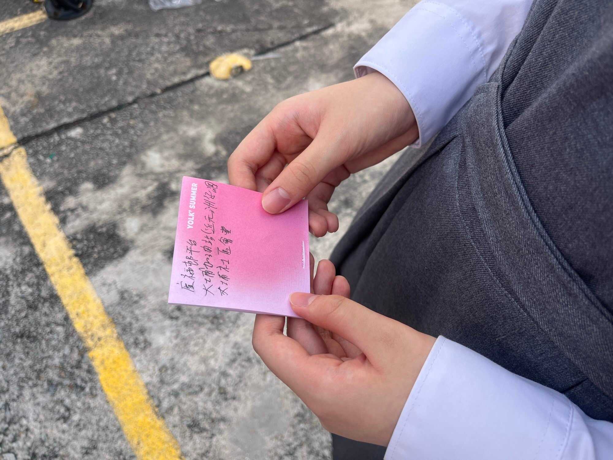 Susan Huang, a 13‑year‑old student from Wong Shiu Chi Secondary School, shows a handwritten note listing the next two places she planned to visit to help victims of the Wang Fuk Court fire. Photo: Kelly Fung