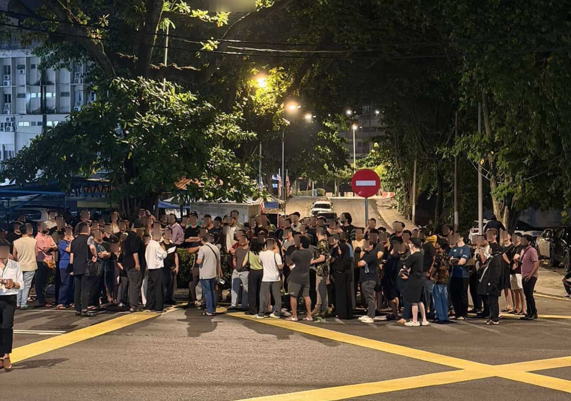 Volunteers, lawyers, family members and friends gather outside Kuala Lumpur’s Dang Wangi police station in solidarity with detainees from the men’s spa raid in Chow Kit. Faces blurred to protect identities. Photo: Jejaka/Handout