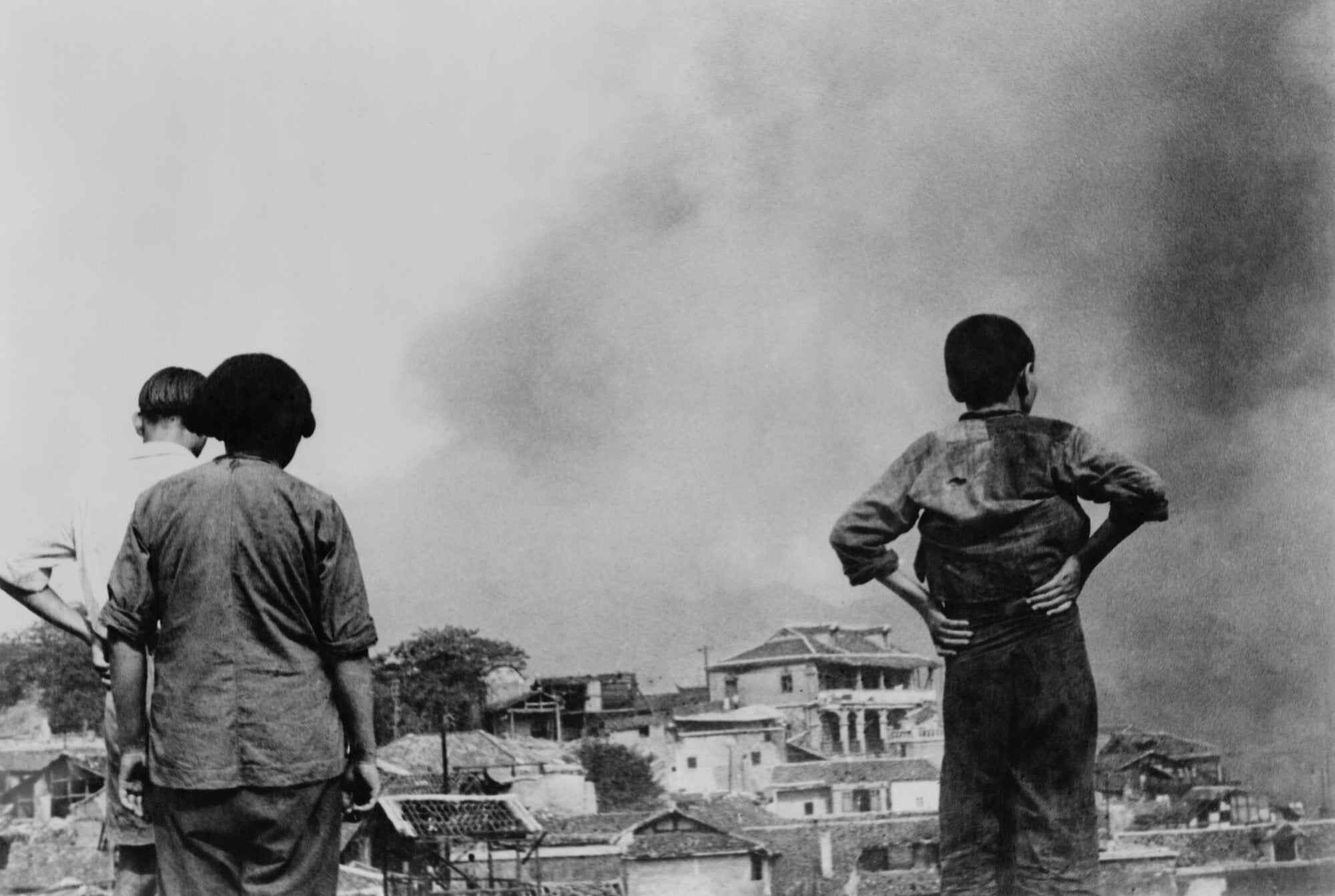 Three Chinese civilians in Chongqing witness a Japanese air raid during the Second Sino-Japanese War during World War II. Photo: Shutterstock