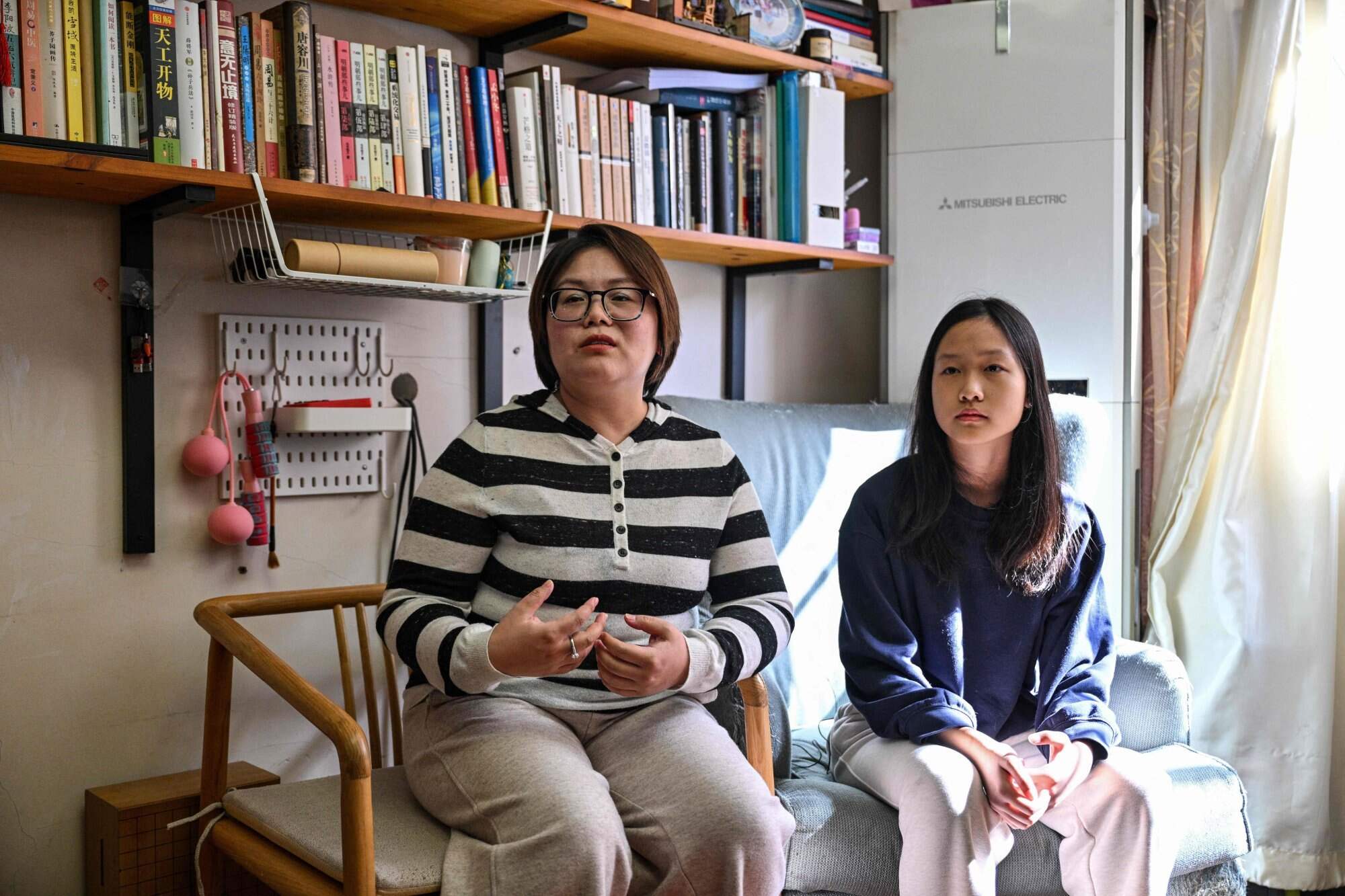 Estella sits next to her mother Xu Zoe (left). Photo: AFP