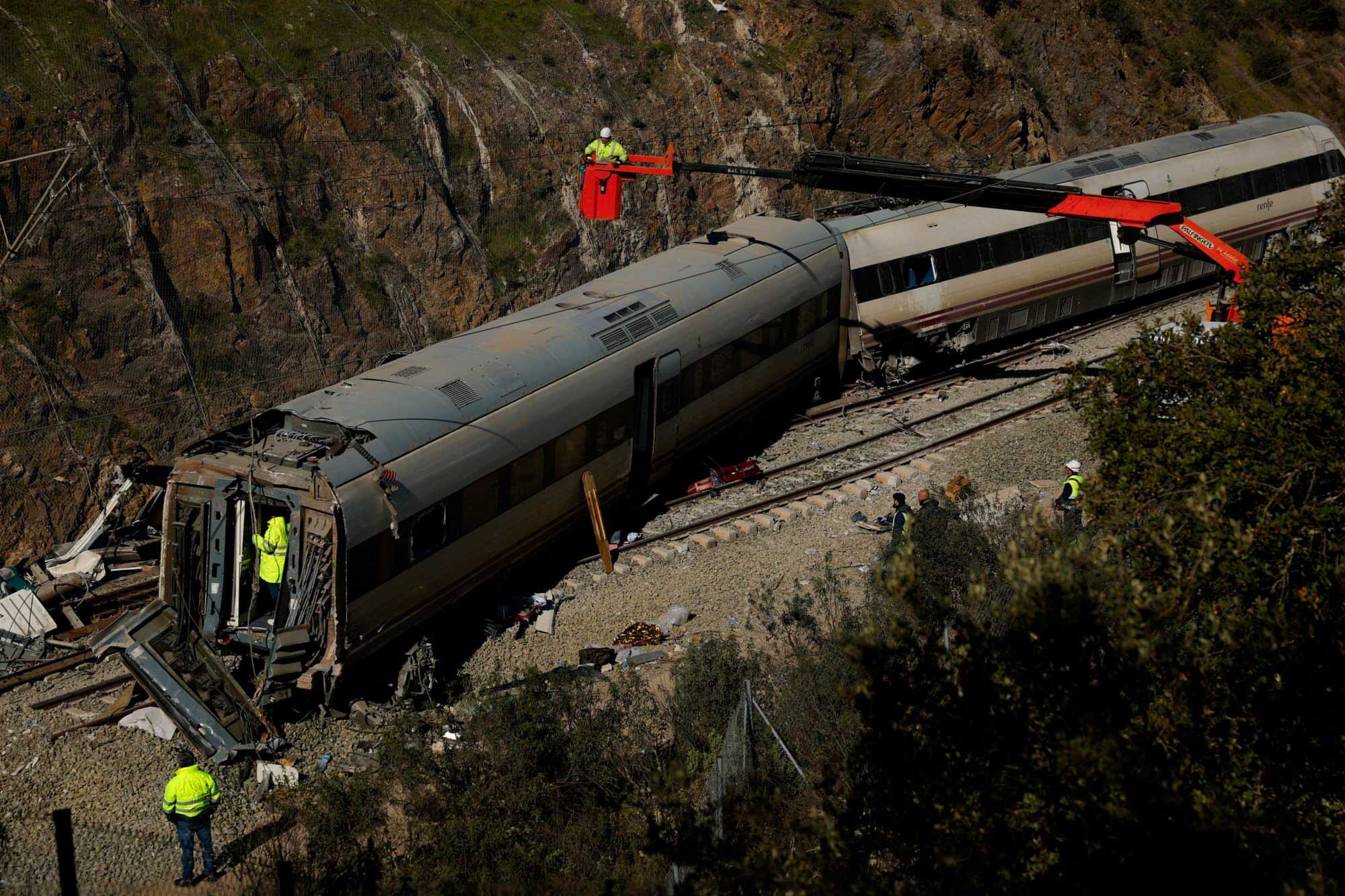 Maintenance workers from rail operator Adif at the wreckage of a train involved in Sunday’s deadly derailment of two high-speed trains. Photo: Reuters