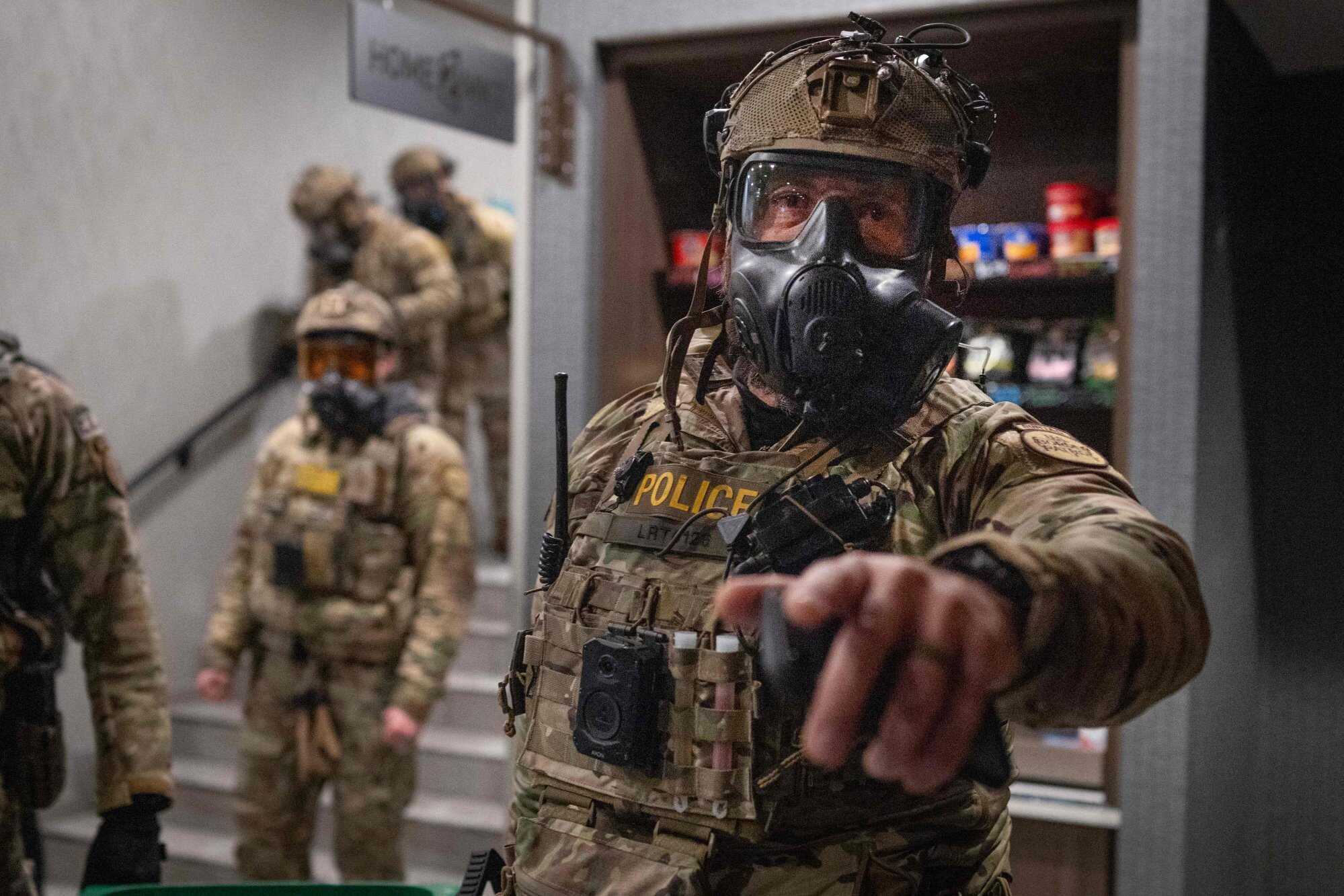 Federal agents enter a lobby after breaking up a protest outside a hotel in Minneapolis, Minnesota. Photo: AFP