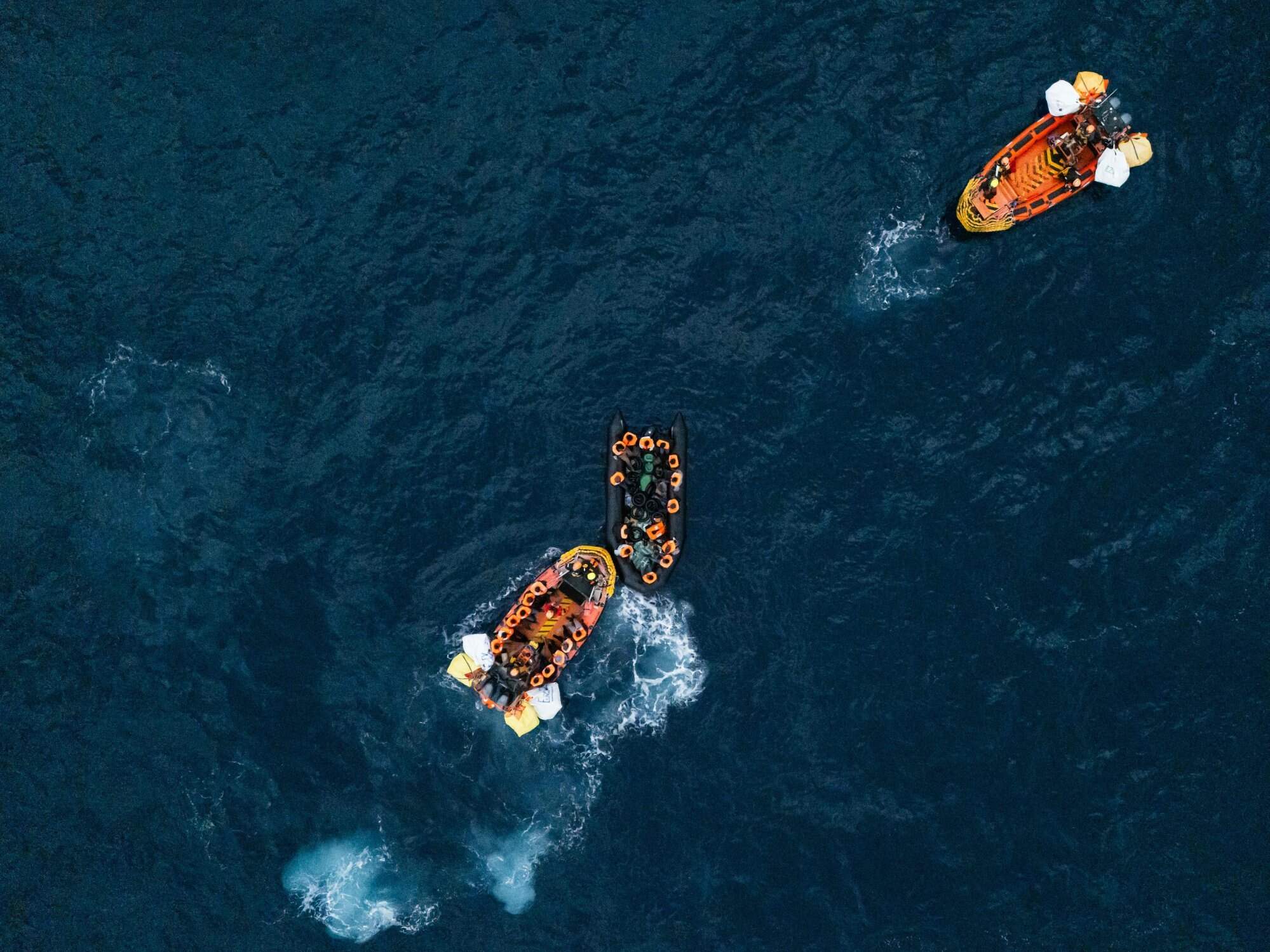 This aerial photograph shows crew members of the ‘Ocean Viking’ rescue ship rescuing a boat carrying migrants in distress using an RHIB (rigid inflatable boat) in the search-and-rescue zone off the international waters of Libya on January 16, 2026. Photo: AFP