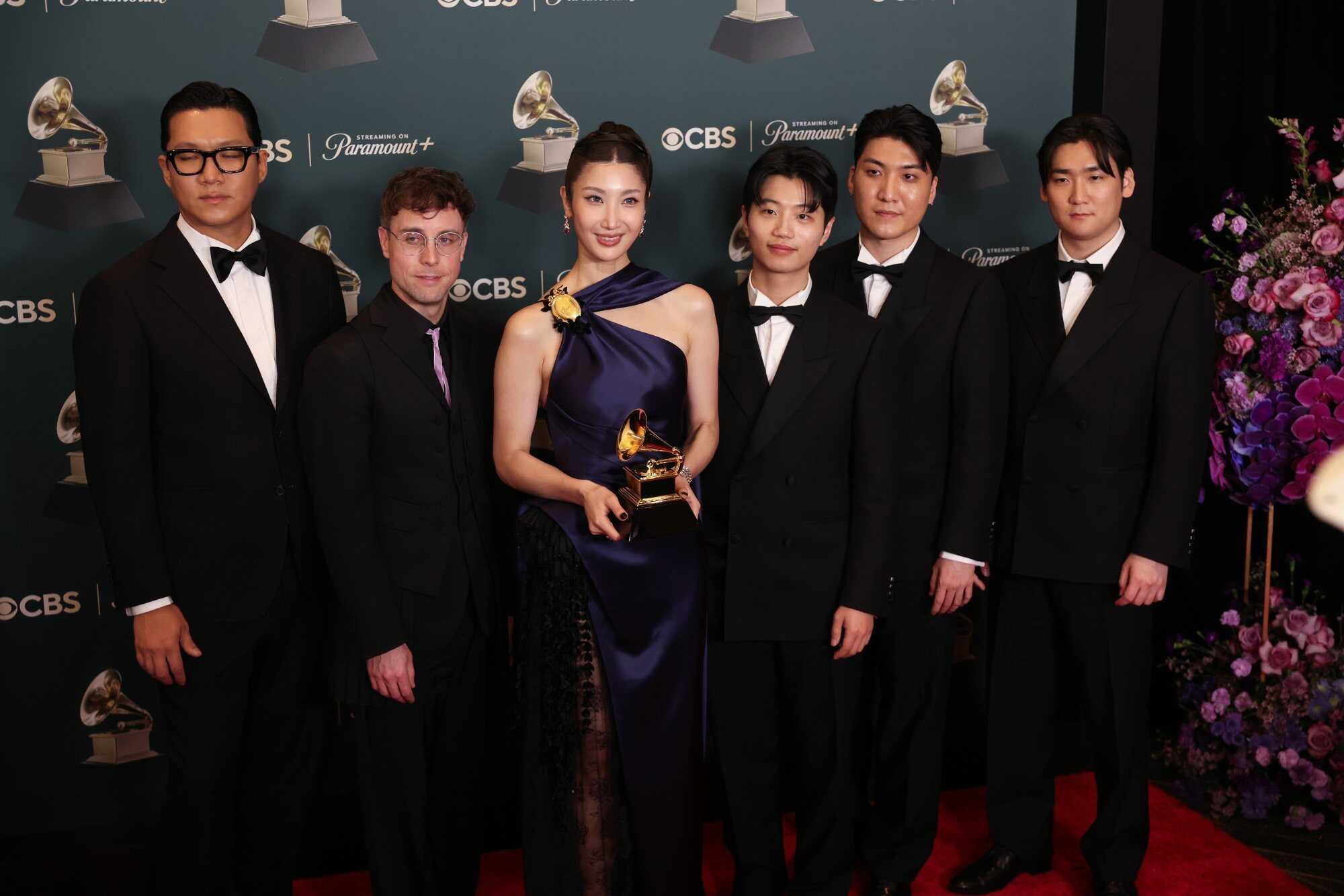 The team from ‘KPop Demon Hunters’ pose in the press room with the award for Best Song Written For Visual media for ‘Golden’. Photo: EPA