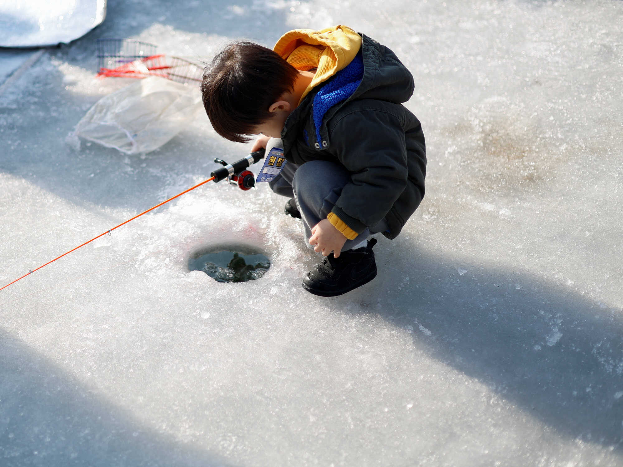 A boy fishes on a frozen river during the Hwacheon Ice Festival in Hwacheon, South Korea on January 17, 2026. Photo: Reuters
