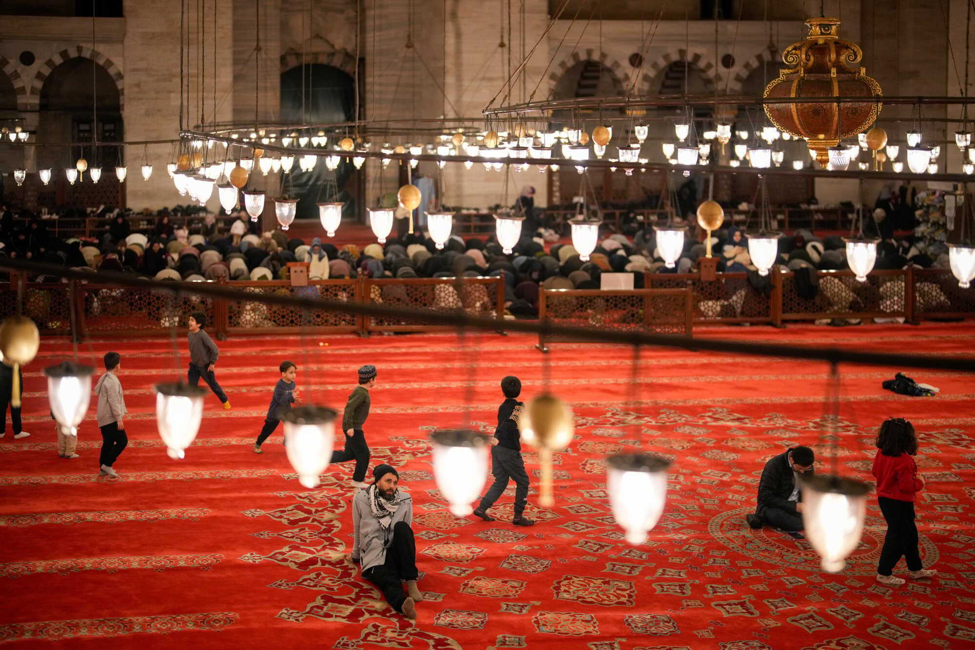 A worshipper rests as others perform the night prayer known as Tarawih on the eve of the first day of the Muslim holy month of Ramadan at the Suleymaniye Mosque in Istanbul. Photo: AP