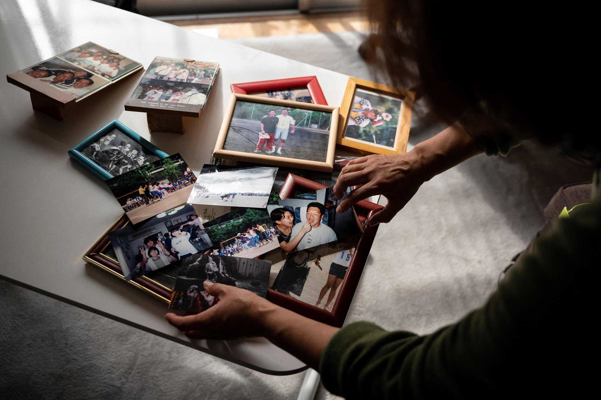 Sachiko Kudo, widow of former Japanese teacher Yoshio Kudo, who died in 2007 from “karoshi” or death from overwork, displays old photographs of her husband during an interview at her home in Machida, a city in the greater Tokyo area. Photo: AFP