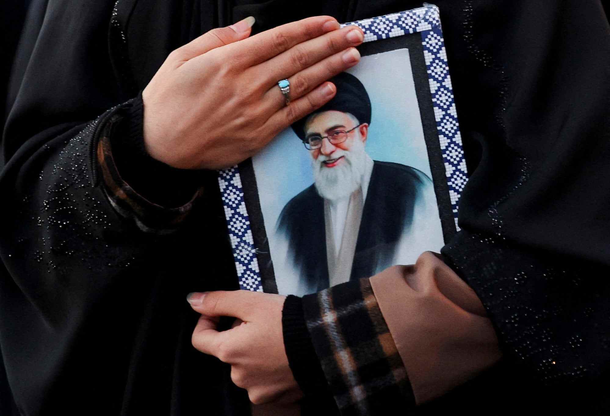 A woman holds on to a picture of Iran’s Supreme Leader Ayatollah Ali Khamenei at Enghelab Square in Tehran, after he was killed in Israeli and US strikes on Saturday. Photo: Reuters