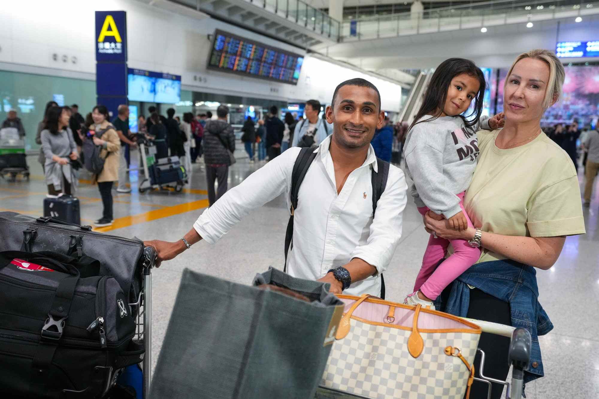 Karis Teetan with his family, returning from Dubai on the first plane of Hongkongers who had been stranded in the UAE. Photo: Sam Tsang