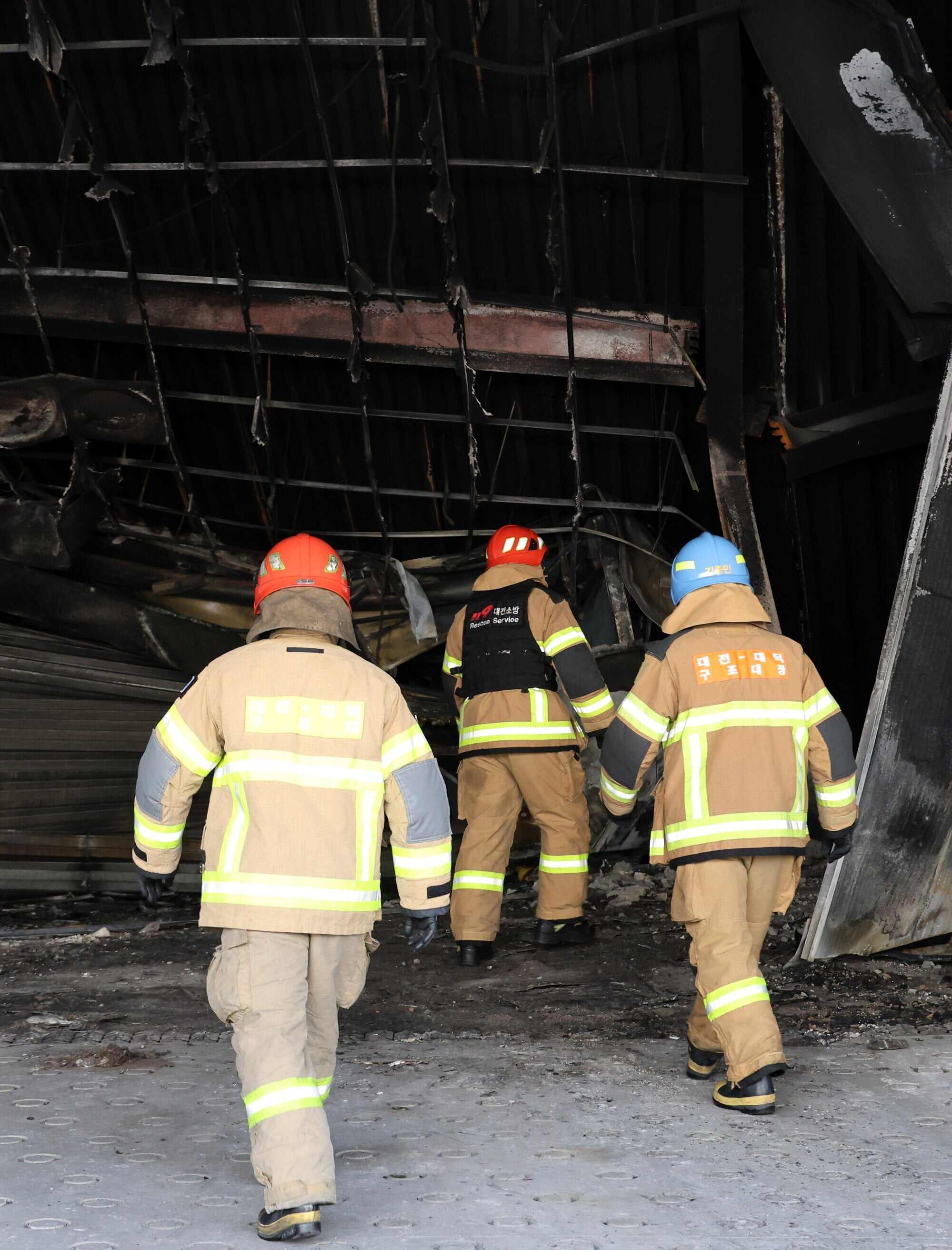 Police officers and firefighters examine the site of the fire three days later. The blaze left 14 workers dead and 60 others injured. Photo: EPA/Yonhap