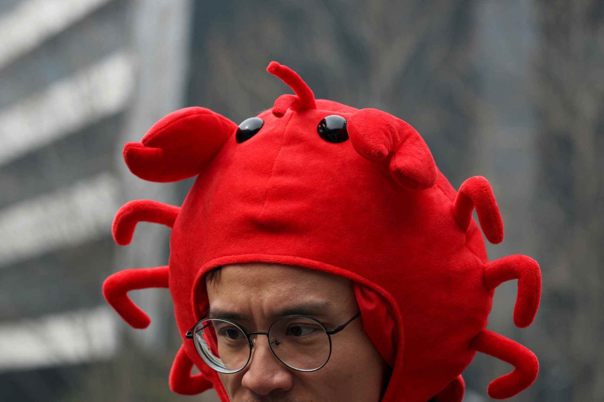 A staff member wears a lobster hat representing open-source AI agent OpenClaw’s logo. Photo: Reuters