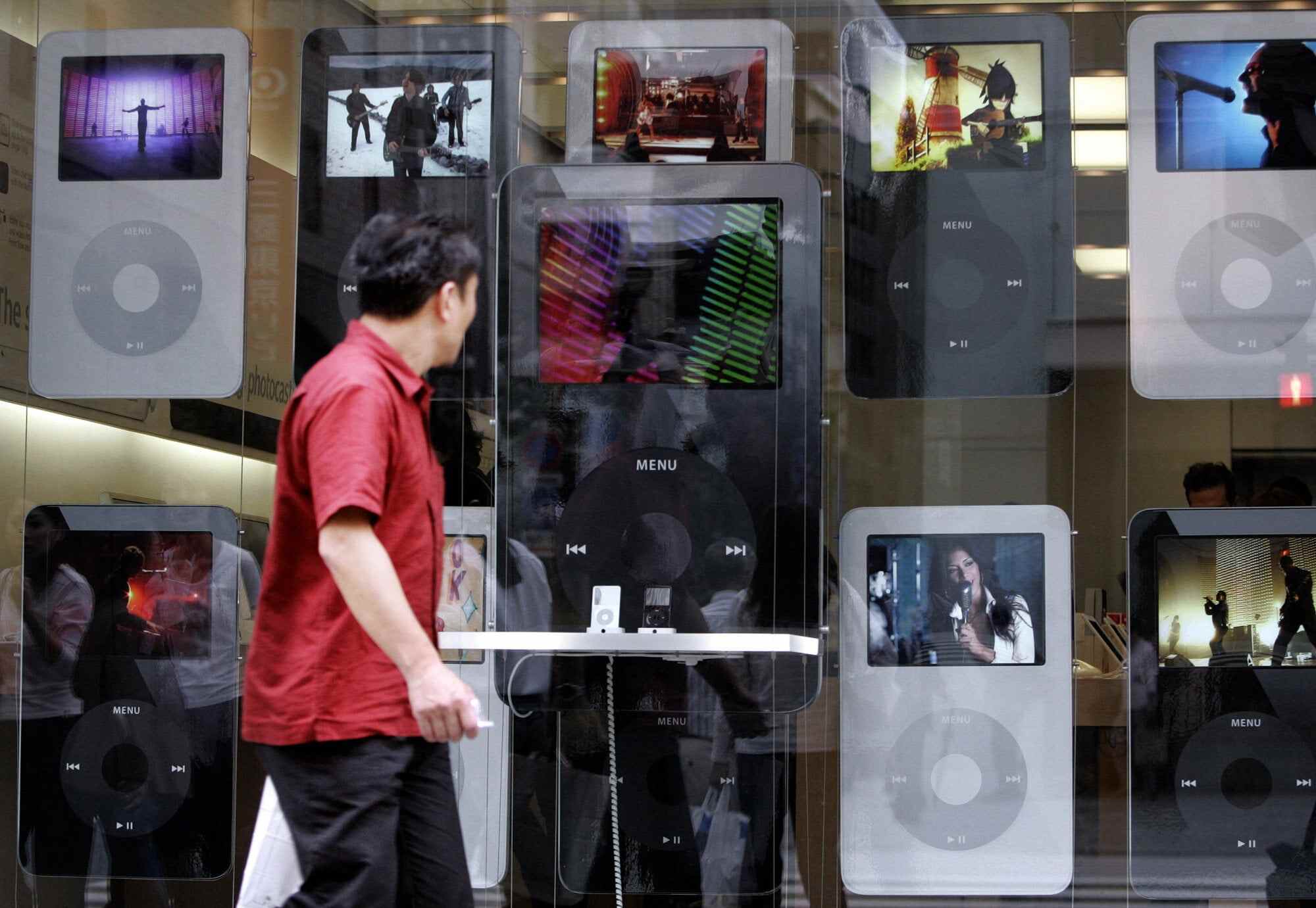 A pedestrian looks at iPods displayed at the Apple Store in central Tokyo in September 2006. Despite being officially discontinued in 2022, sales of the music player are booming – at least for second-hand devices. Photo: AFP