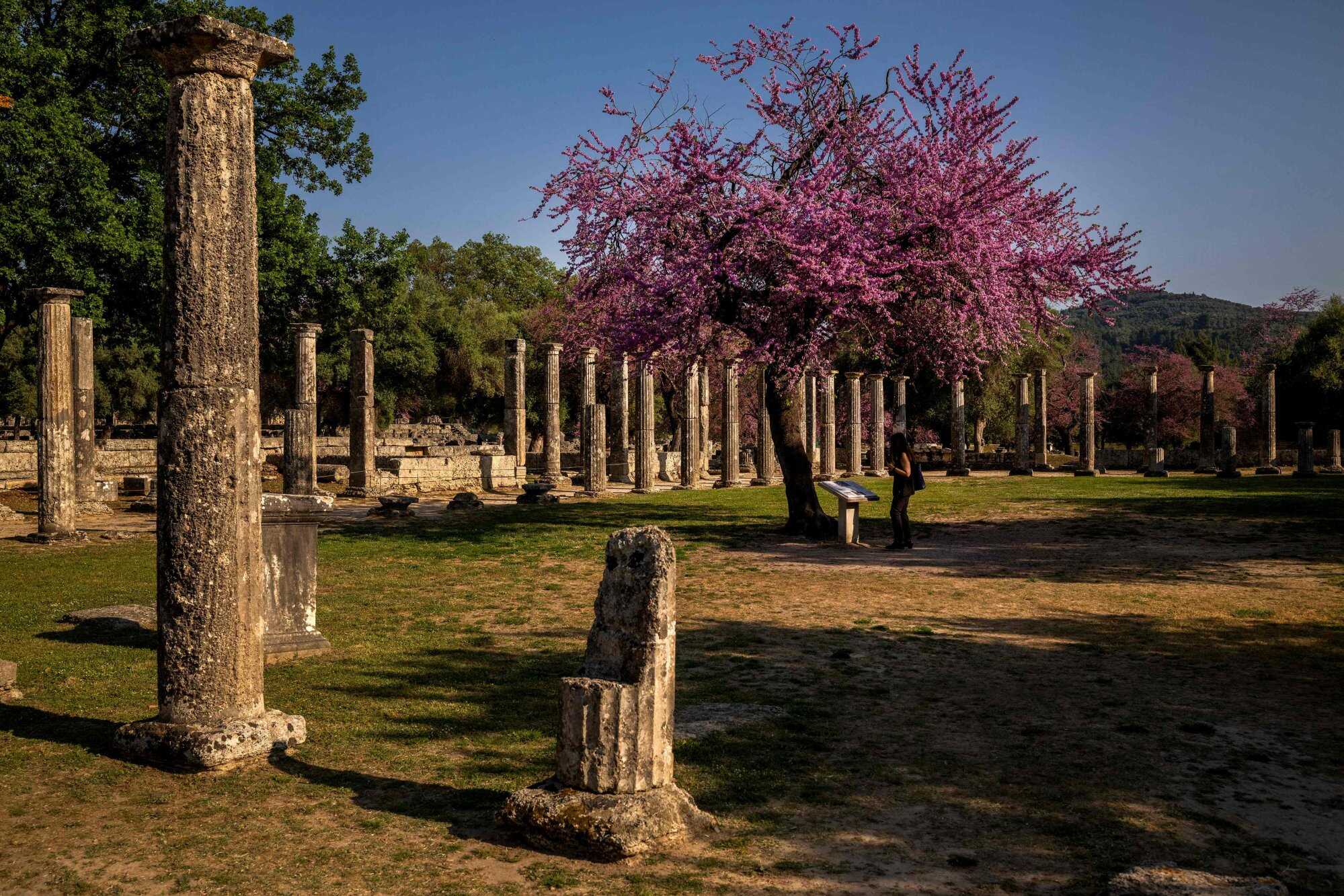 A woman at the archaeological site of Olympia on April 14, 2024. The area is habitually threatened by forest fires. Photo: AFP