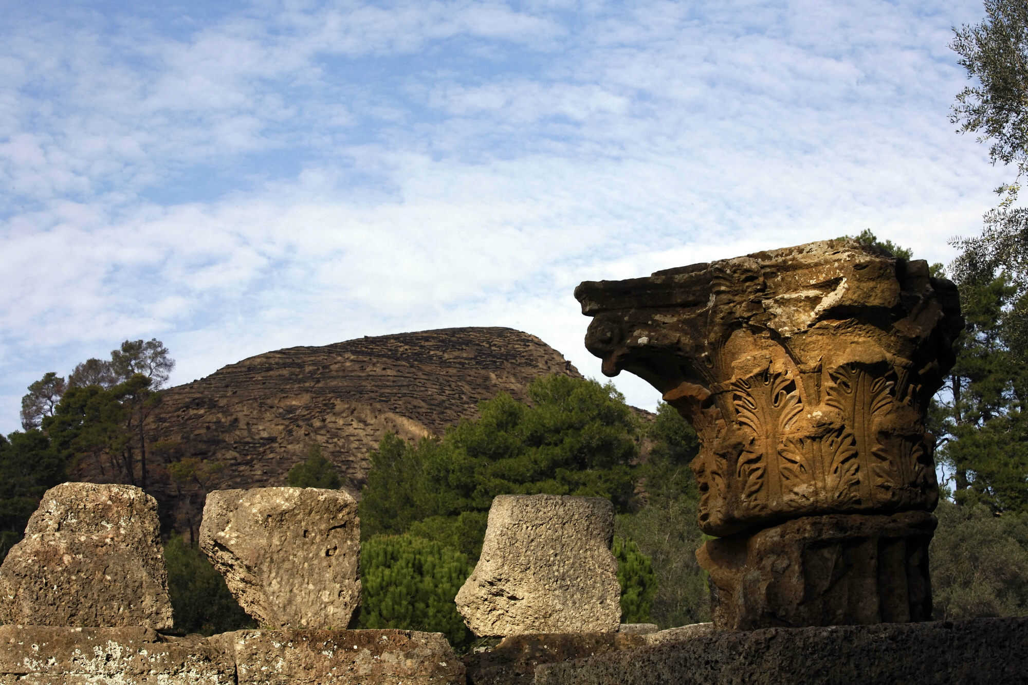 A part of an ancient column in the archaeological site of Olympia stands in front of the charred ancient hill of Kronos on 24 November 2007. Greek and international scientists visited the World Heritage site to deliver funds for the reconstruction of the area. Photo: AFP