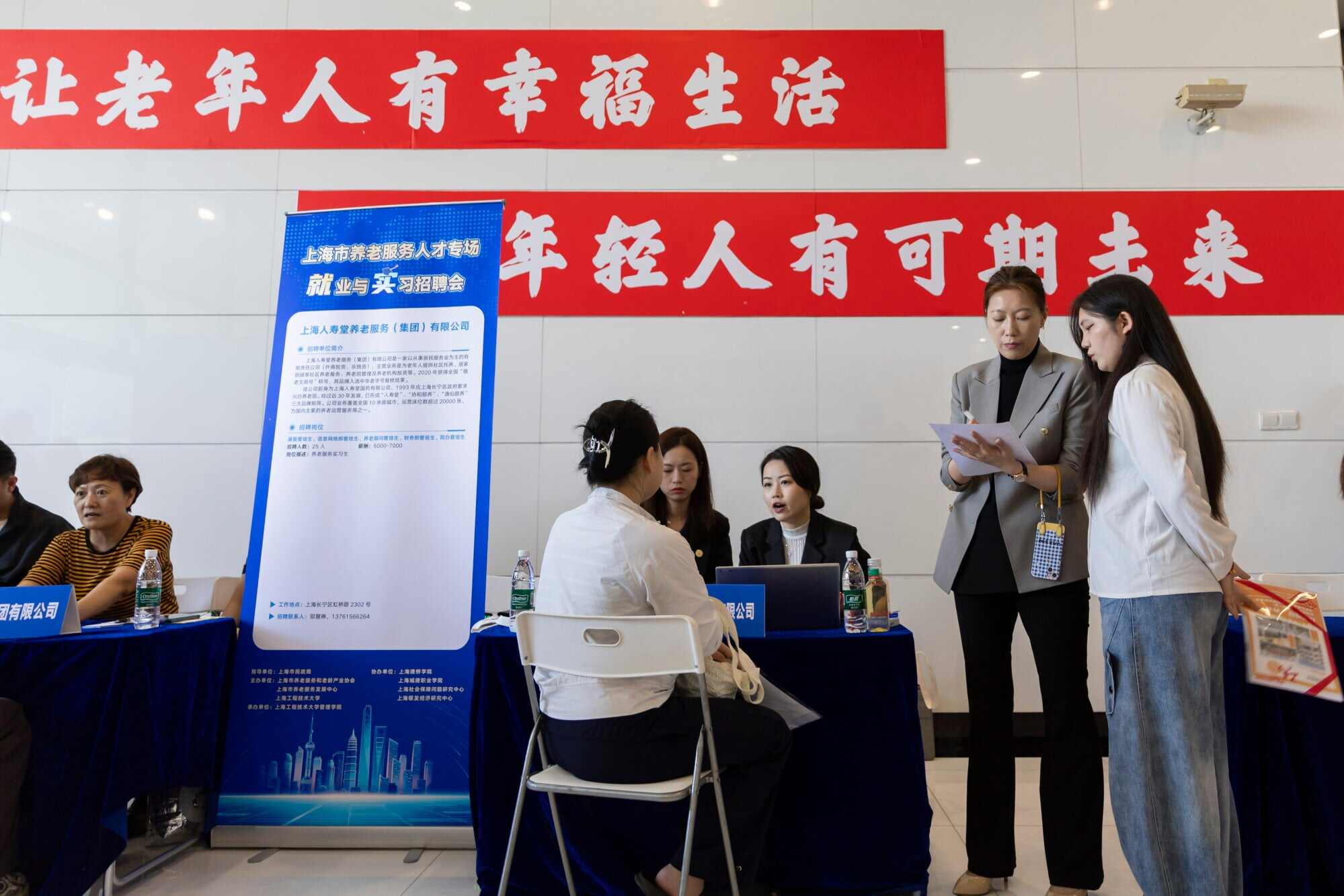 Job seekers talk with recruiters at a job fair. A record 12.7 million students are expected to graduate this summer and enter the job market. Photo: Xinhua