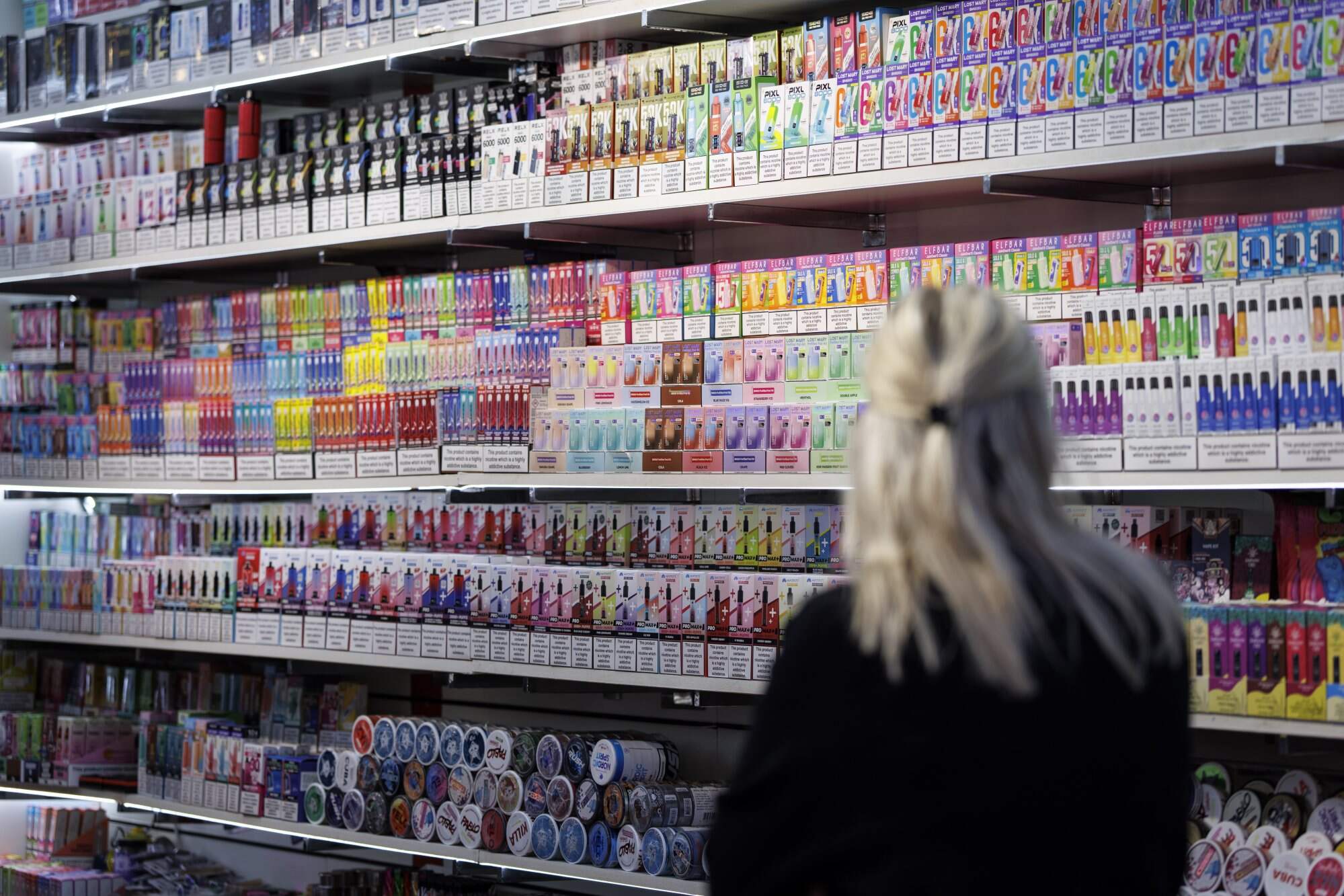 A customer browses vape products displayed at a shop on Oxford Street in London. The new bill gives the government powers to restrict the flavours and packaging of vapes. Photo: EPA
