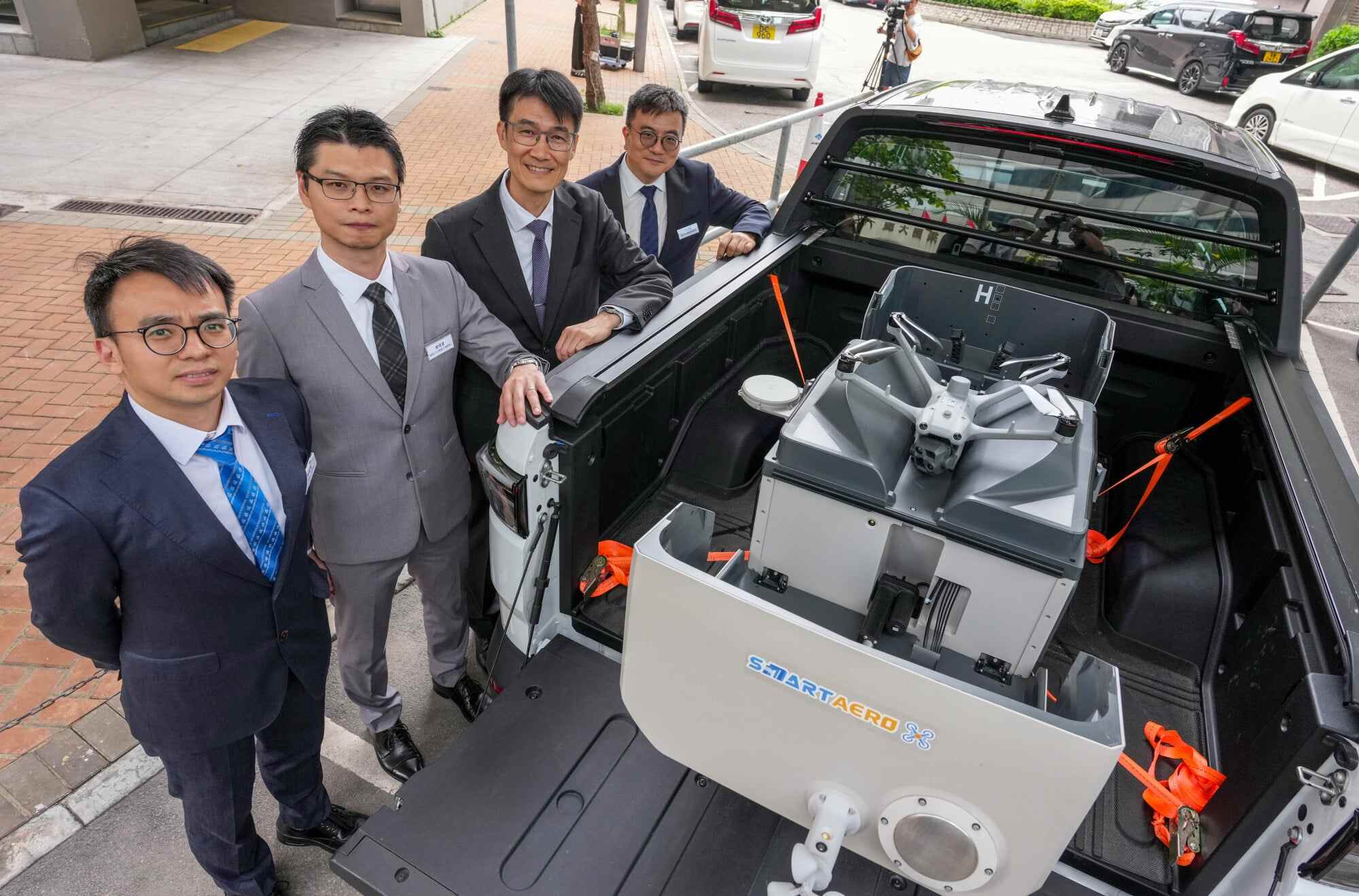 The Civil Engineering and Development Department’s deputy head of the geotechnical engineering office, Lawrence Shum (second from right), poses with a drone that can help monitor landslides. Photo: Karma Lo