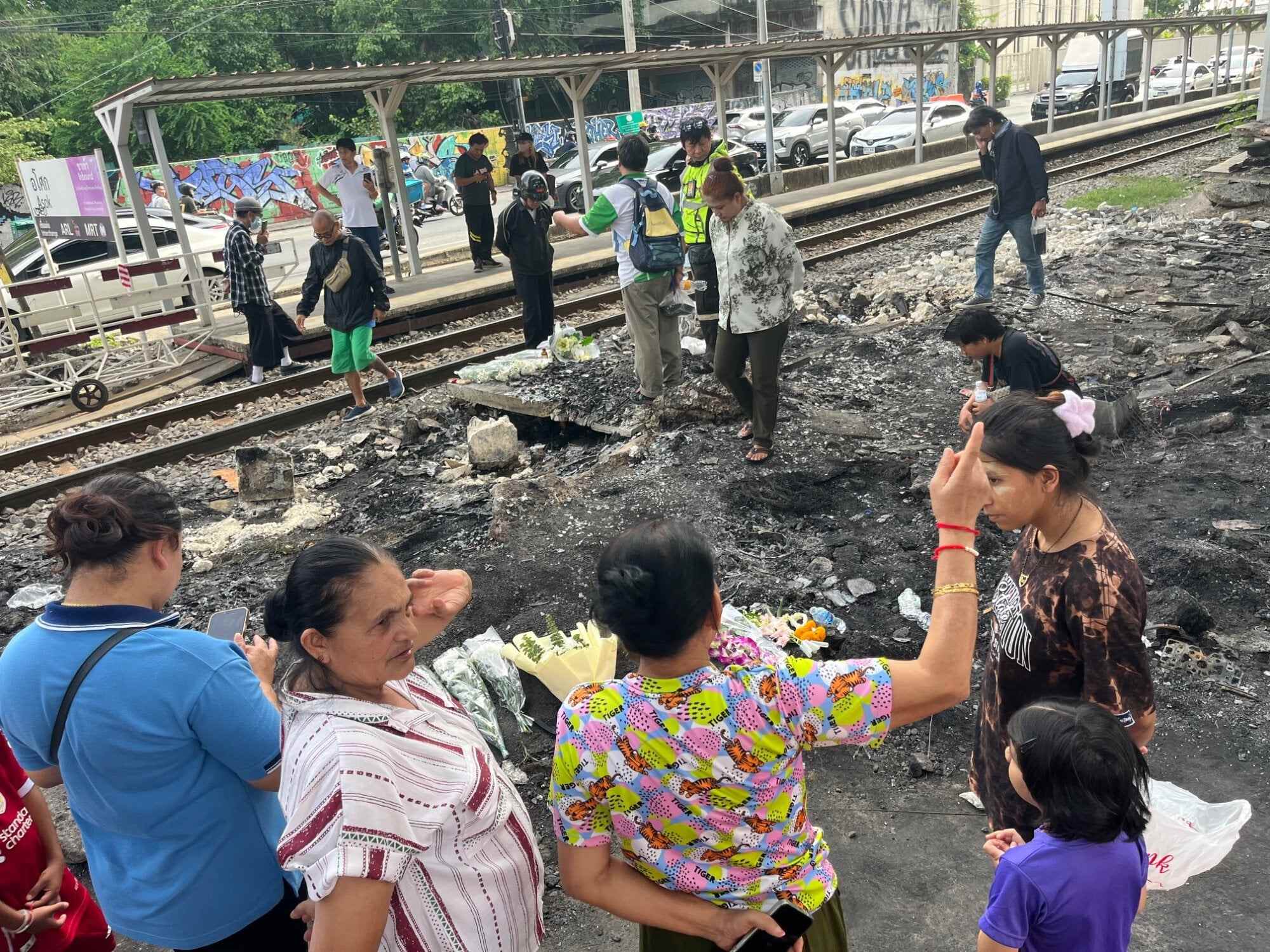 Bangkok residents gather near the site of a deadly train crash on May 16 at the intersection of Sukhumvit Road and Asok Montri Road, a major junction known as Asok intersection. Photo: Aidan Jones