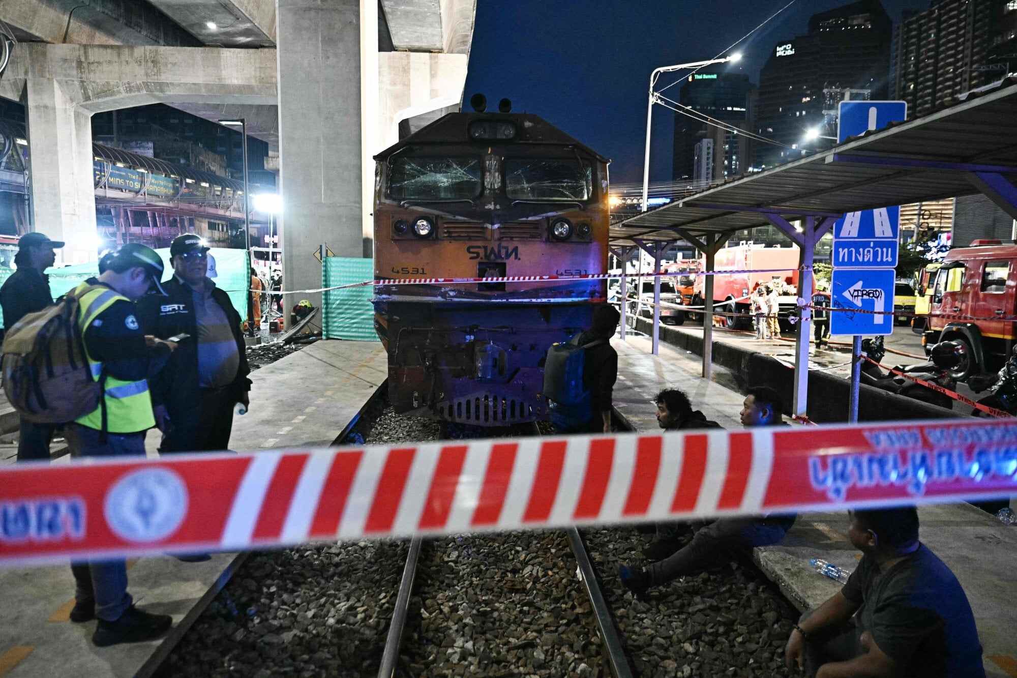 Officials stand next to the front of the train that collided with the bus in Saturday’s accident. Photo: AFP
