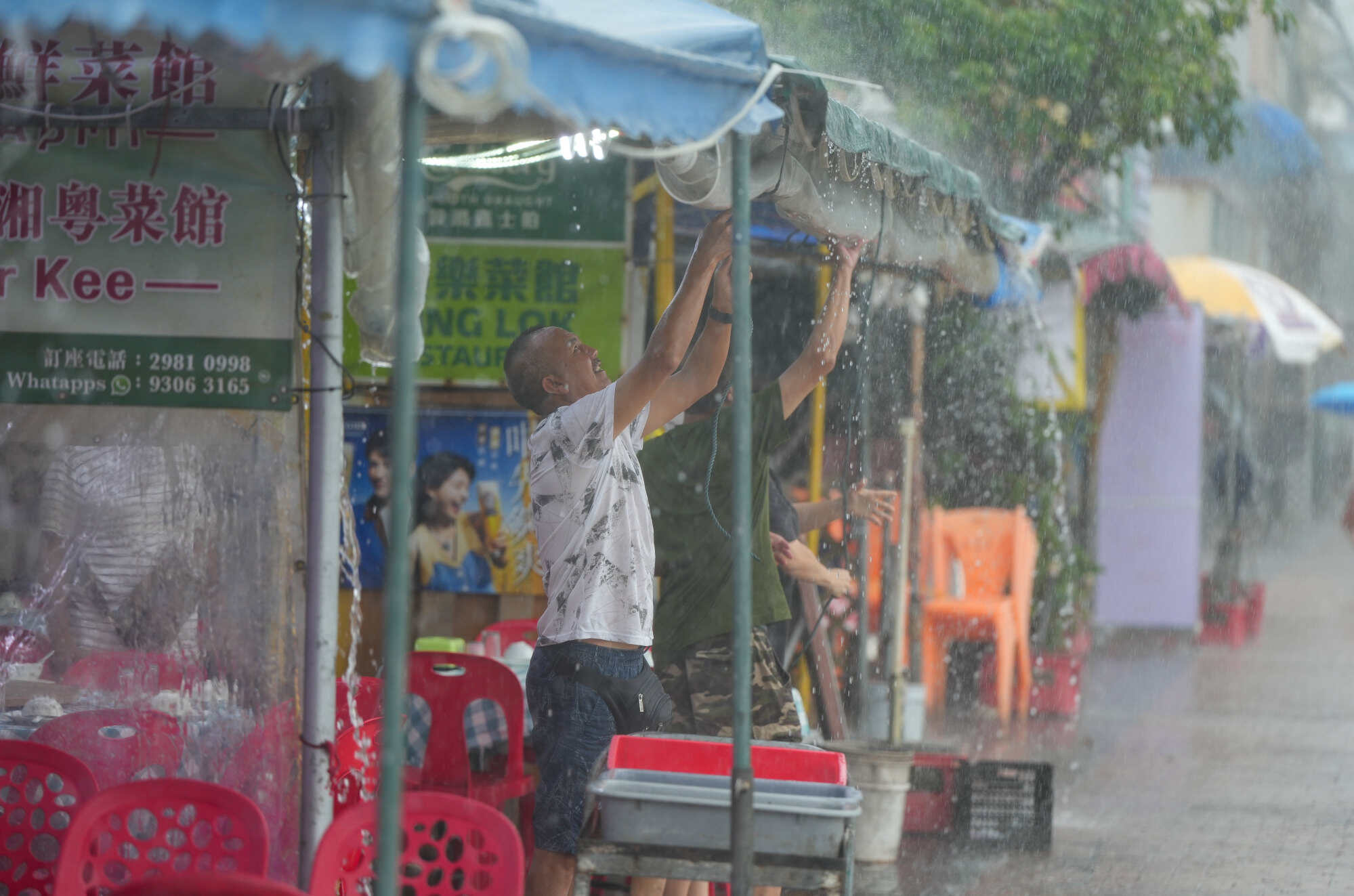People set up a rain-prevention cover in a restaurant at Cheung Chau during heavy rain. Photo: Sam Tsang