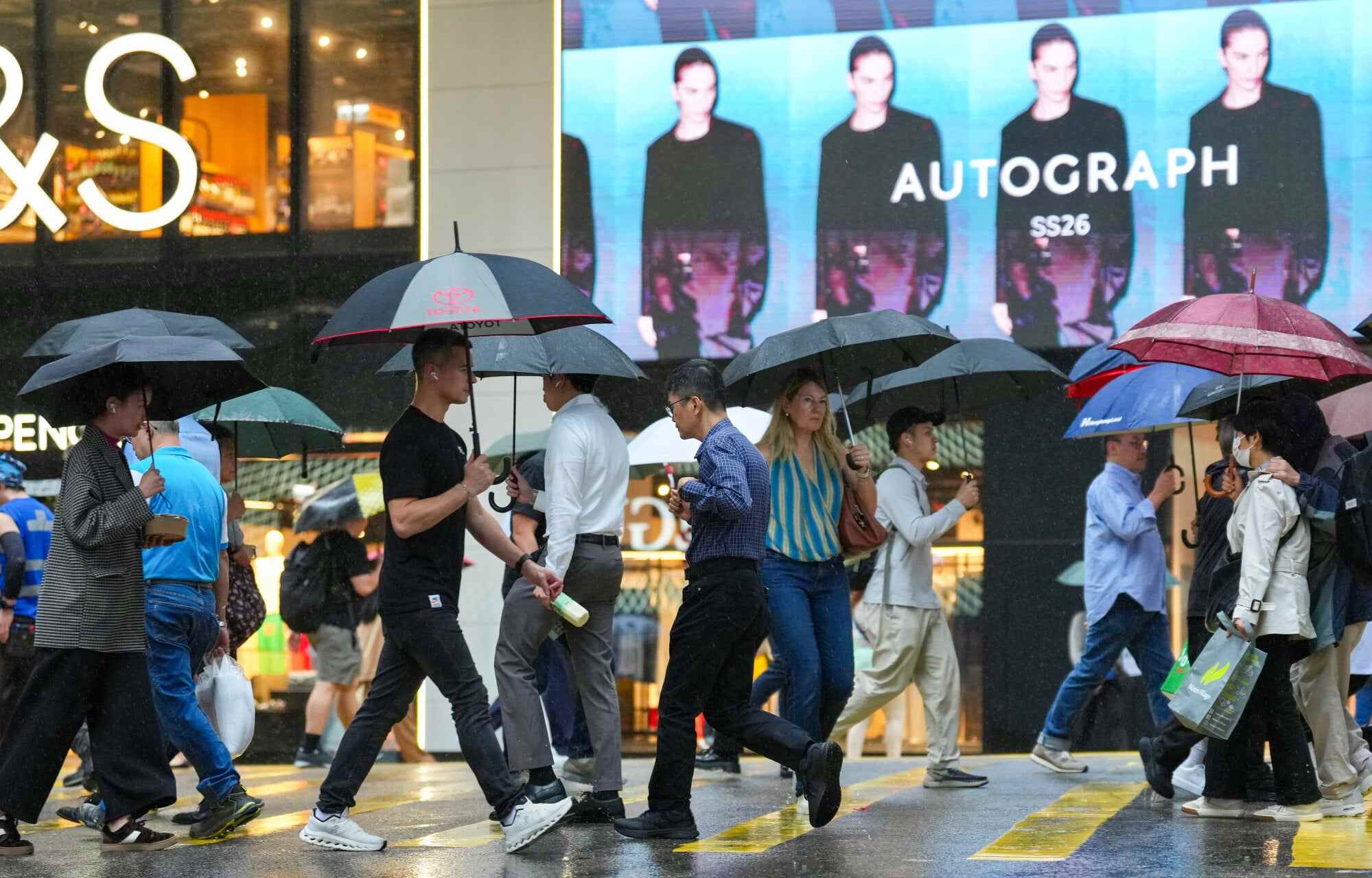 Pedestrians brave the rain in Central as showers sweep across Hong Kong. Photo: Karma Lo
