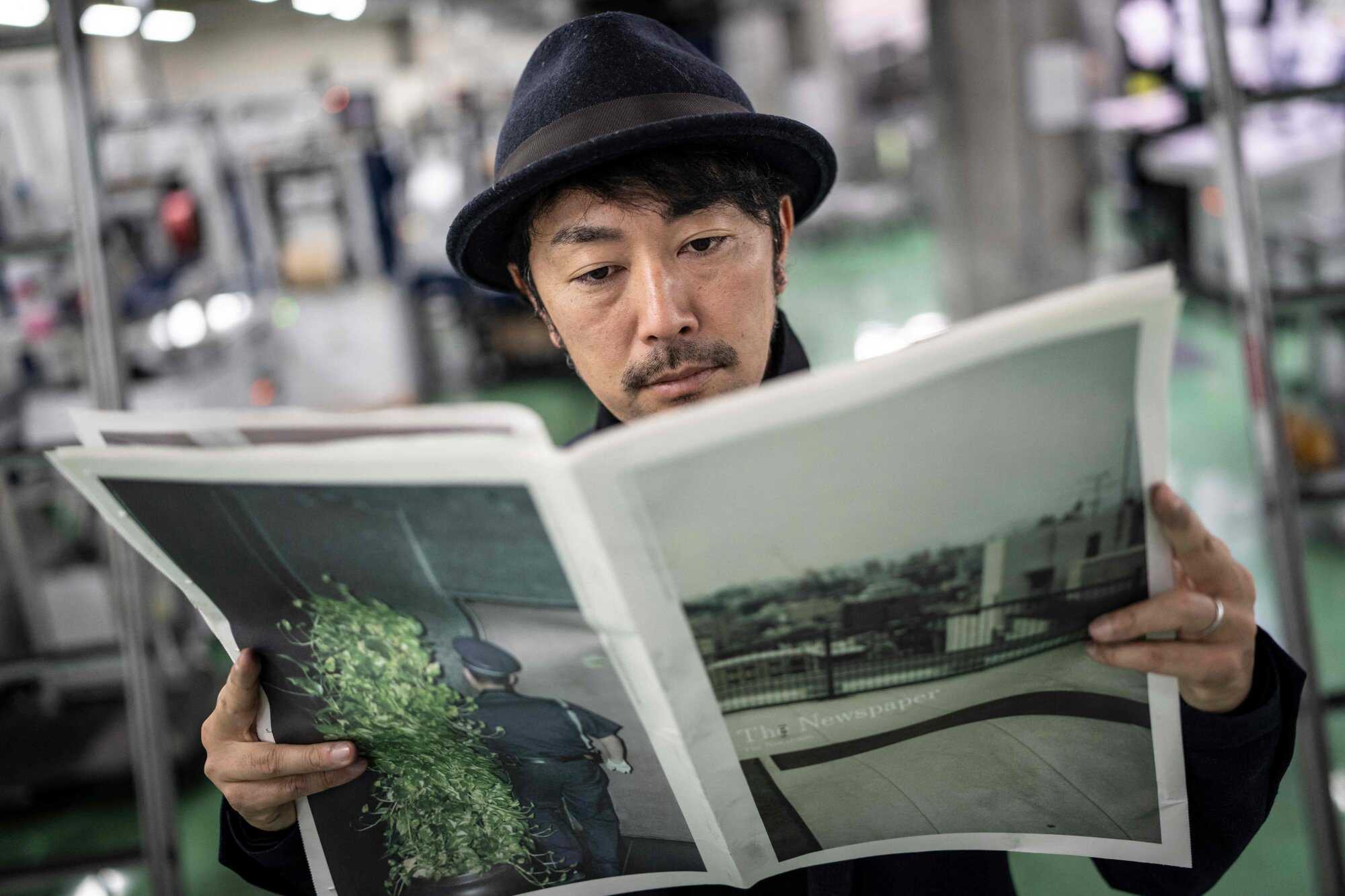 Photographer Kazuma Obara poses with his zine “The Newspaper” at the Kyoto Shimbun factory in Kumiyama, Kyoto prefecture. Photo: AFP