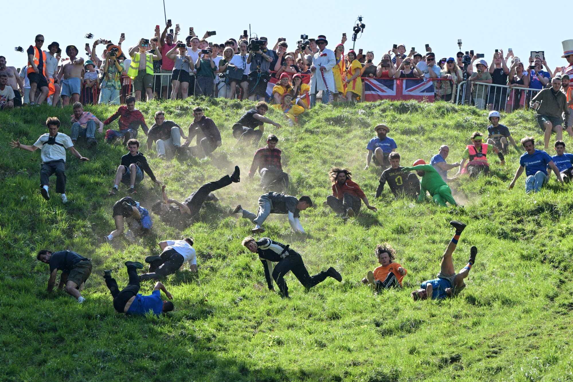Participants compete in the men’s downhill race category of the traditional annual Cheese Rolling contest at Cooper’s Hill in Gloucestershire, England. Photo: AP
