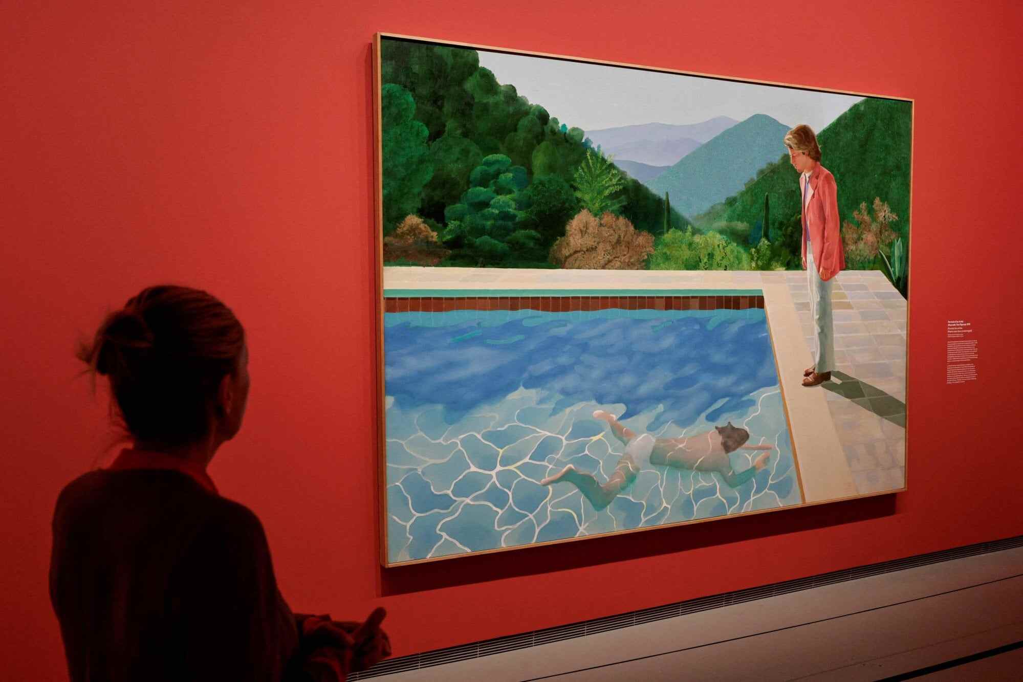 A visitor views the painting “Portrait of an Artist (Pool with Two Figures)” during an exhibition by Hockney in Paris in April 2025. Photo: AFP