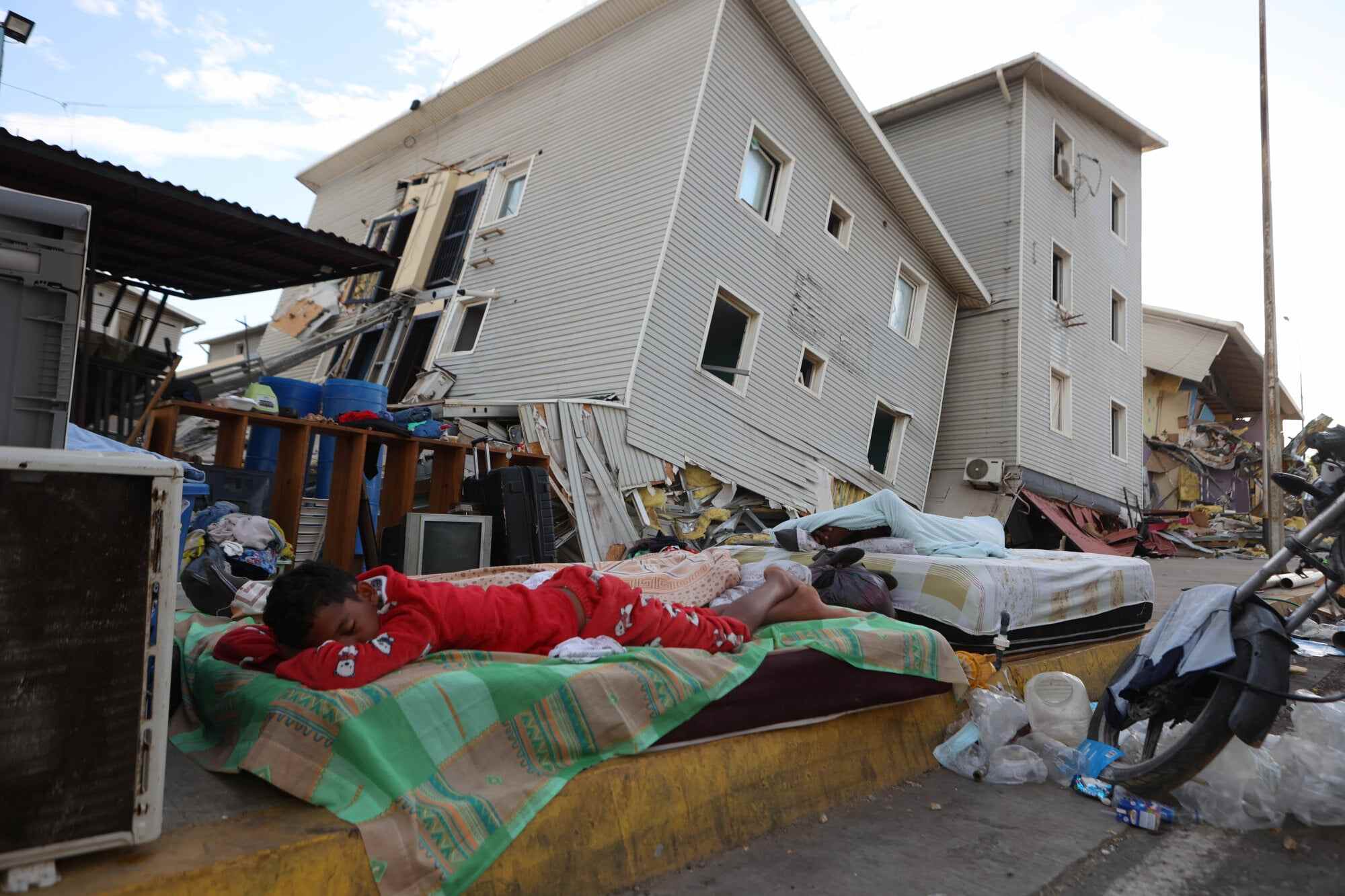 A boy sleeps outside earthquake-damaged homes in Catia La Mar, Venezuela. Photo: AP