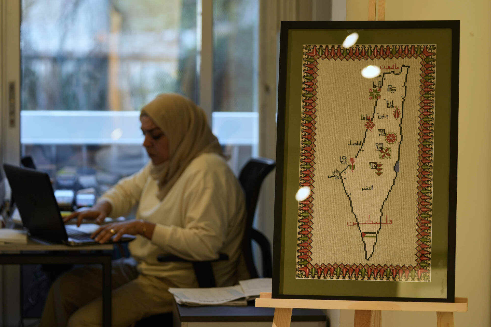 A hand-embroidered map of historic Palestine, with city names and the words “Palestine” and “returning” in Arabic, is displayed at the Inaash Association embroidery workshop in Beirut. Photo: AP
