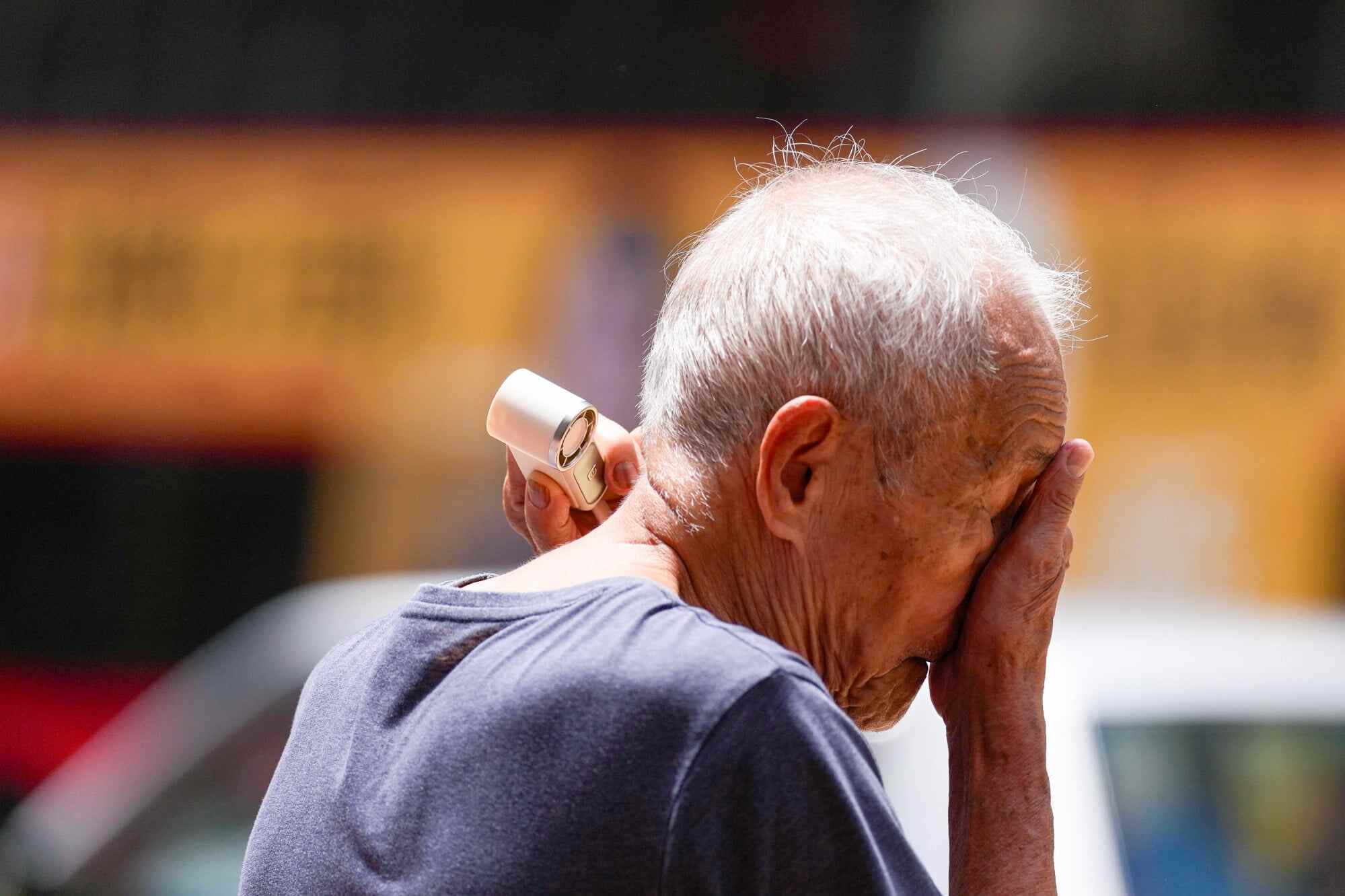 A pedestrian uses a handy fan to beat the heat in Causeway Bay as temperatures rise and the amber heat stress at Work warning remains in force. Photo: Karma Lo