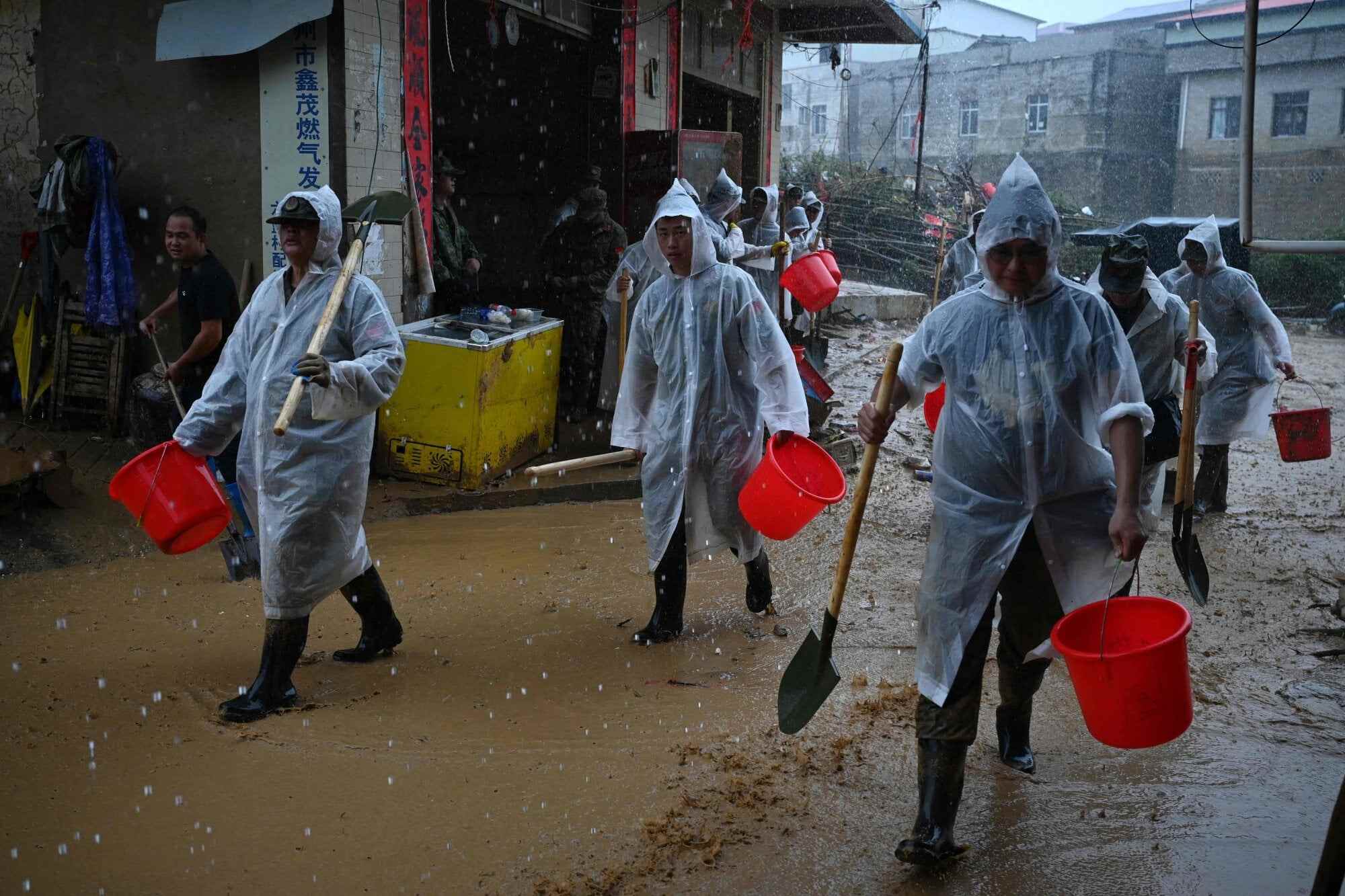 Paramilitary police take part in clean-up operations in Liulan village, which was flooded when the Liulan reservoir collapsed. Photo: AFP