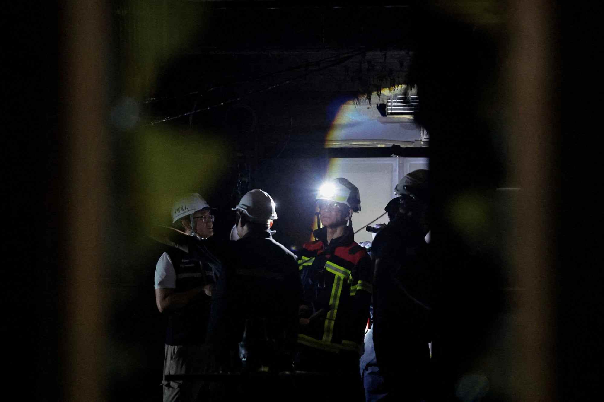 A firefighter wears a helmet with a torch at the site of the deadly fire. Photo: Reuters
